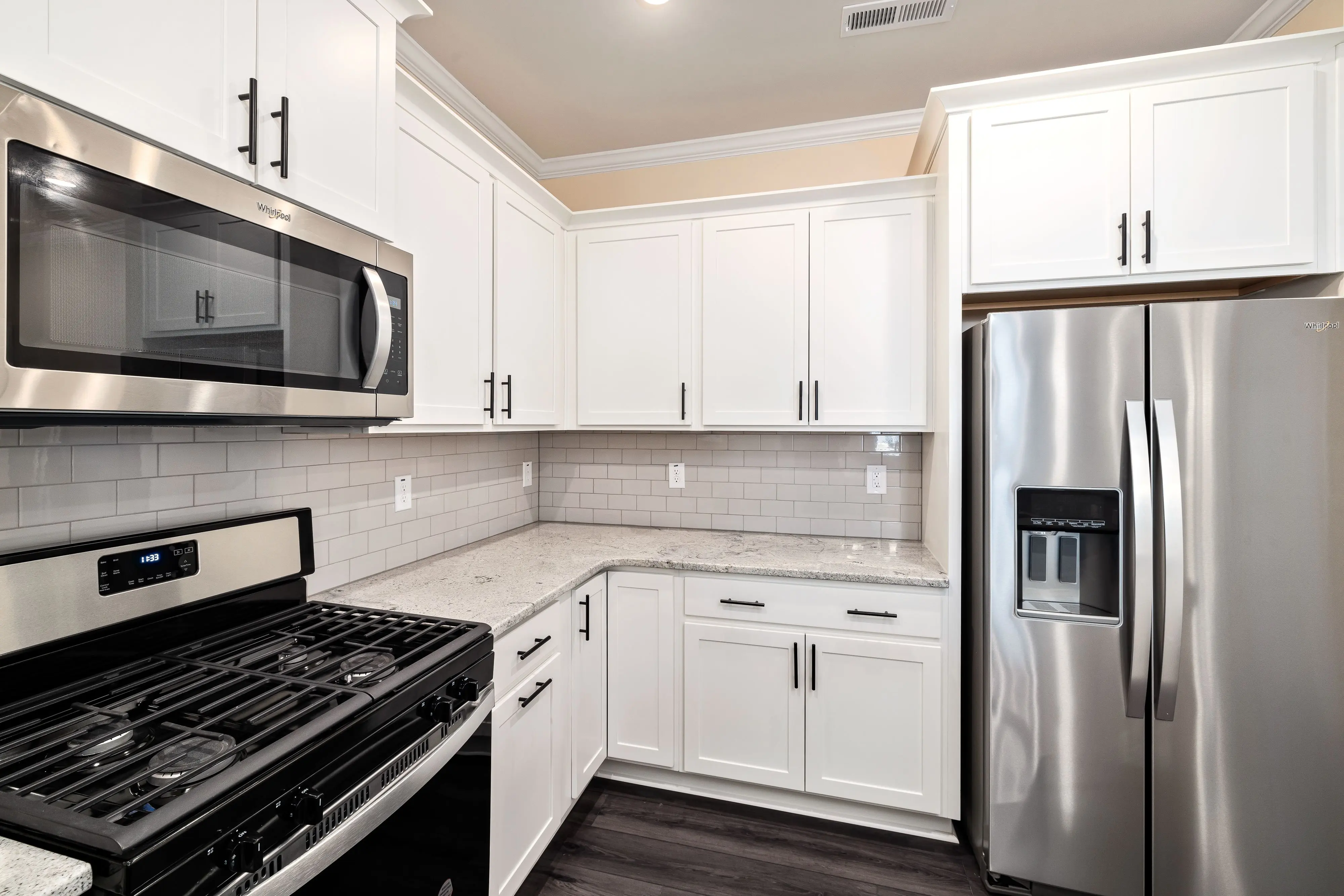 black cabinet knobs Stylish modern kitchen featuring white cabinets and stainless steel appliances.