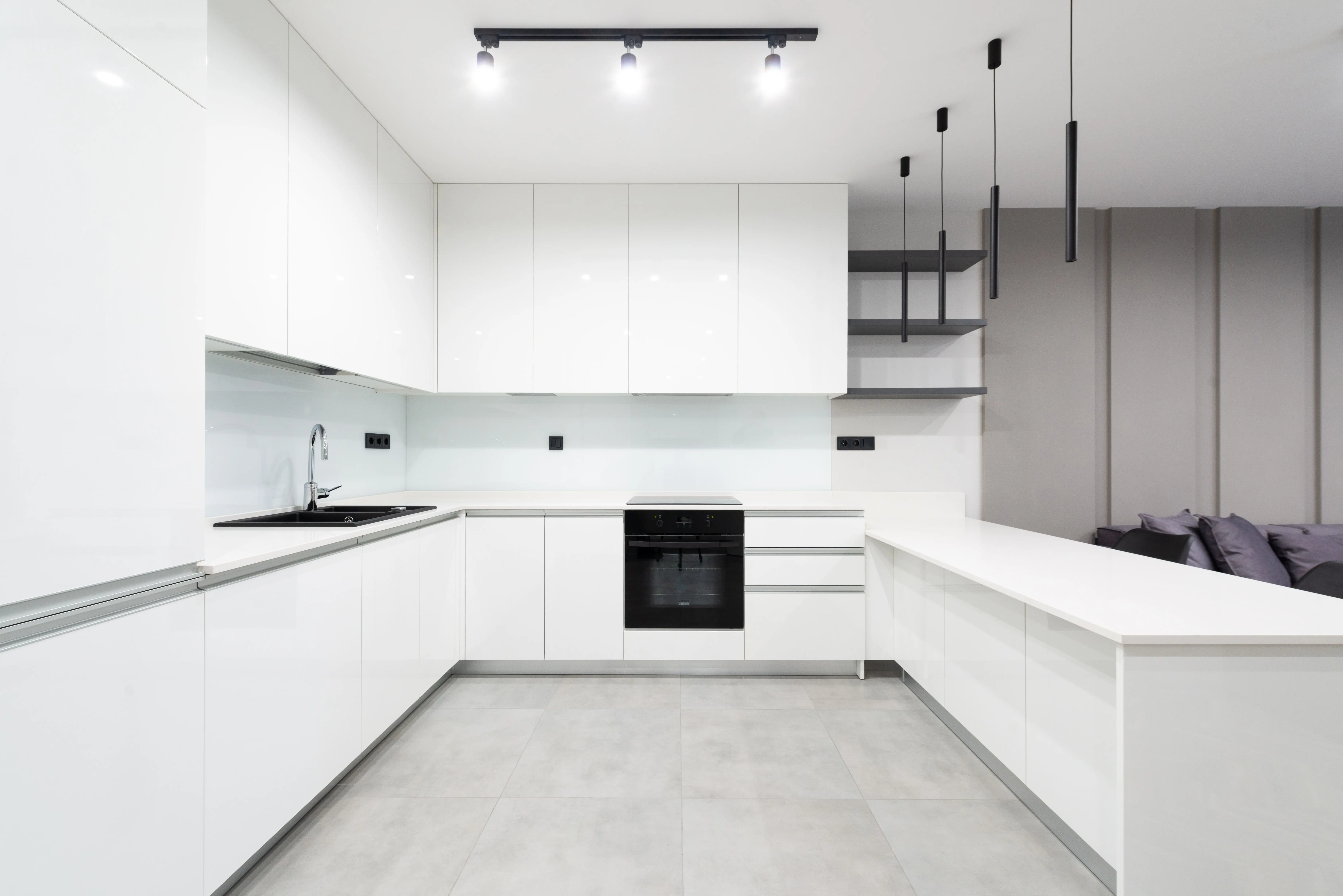dark gray kitchen cabinets Elegant white minimalist kitchen featuring sleek cabinetry and modern lighting.