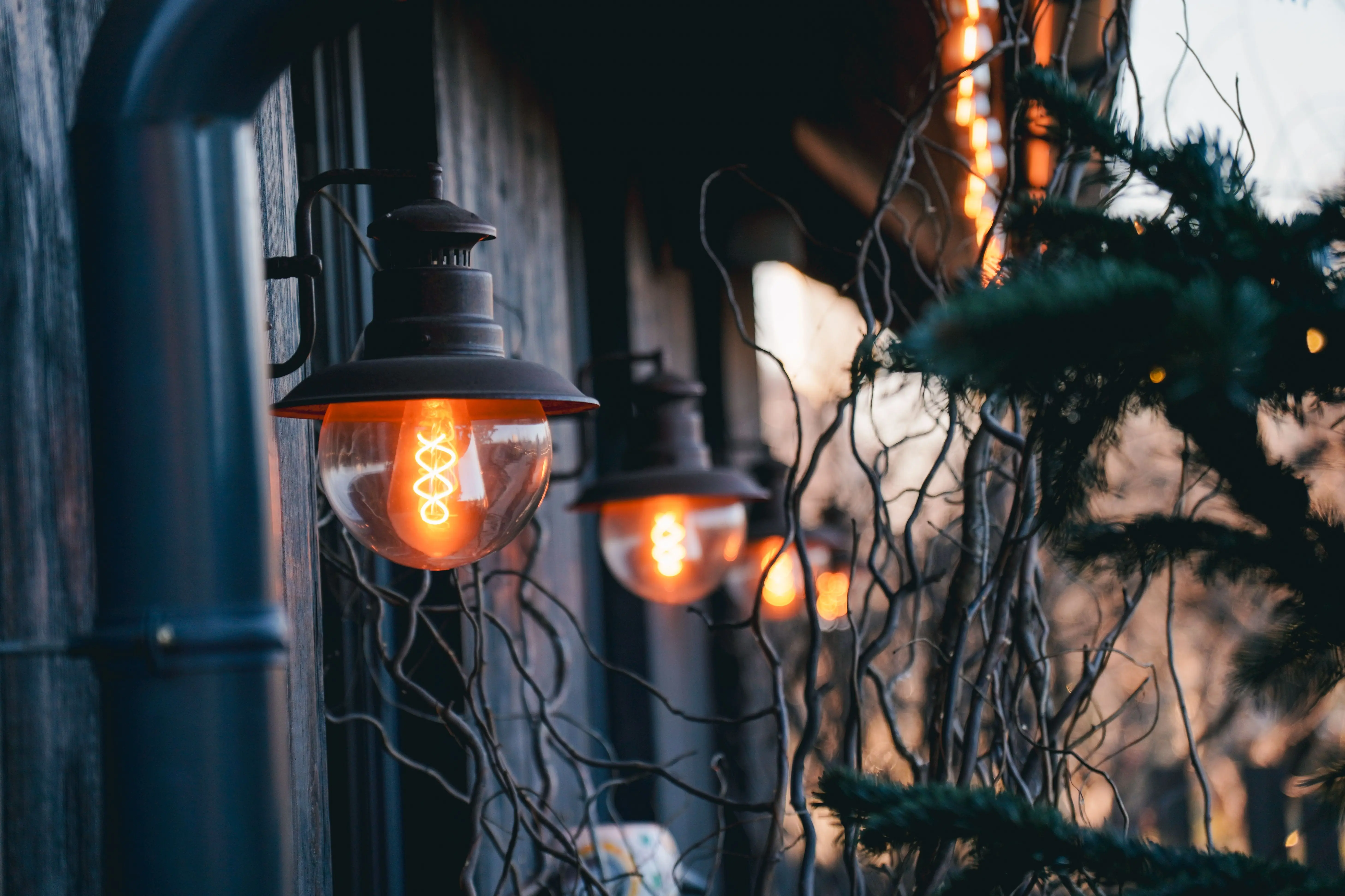 sconce outdoor wall light Warm glowing lamps illuminate a rustic exterior in Kyiv, Ukraine, creating a cozy atmosphere.