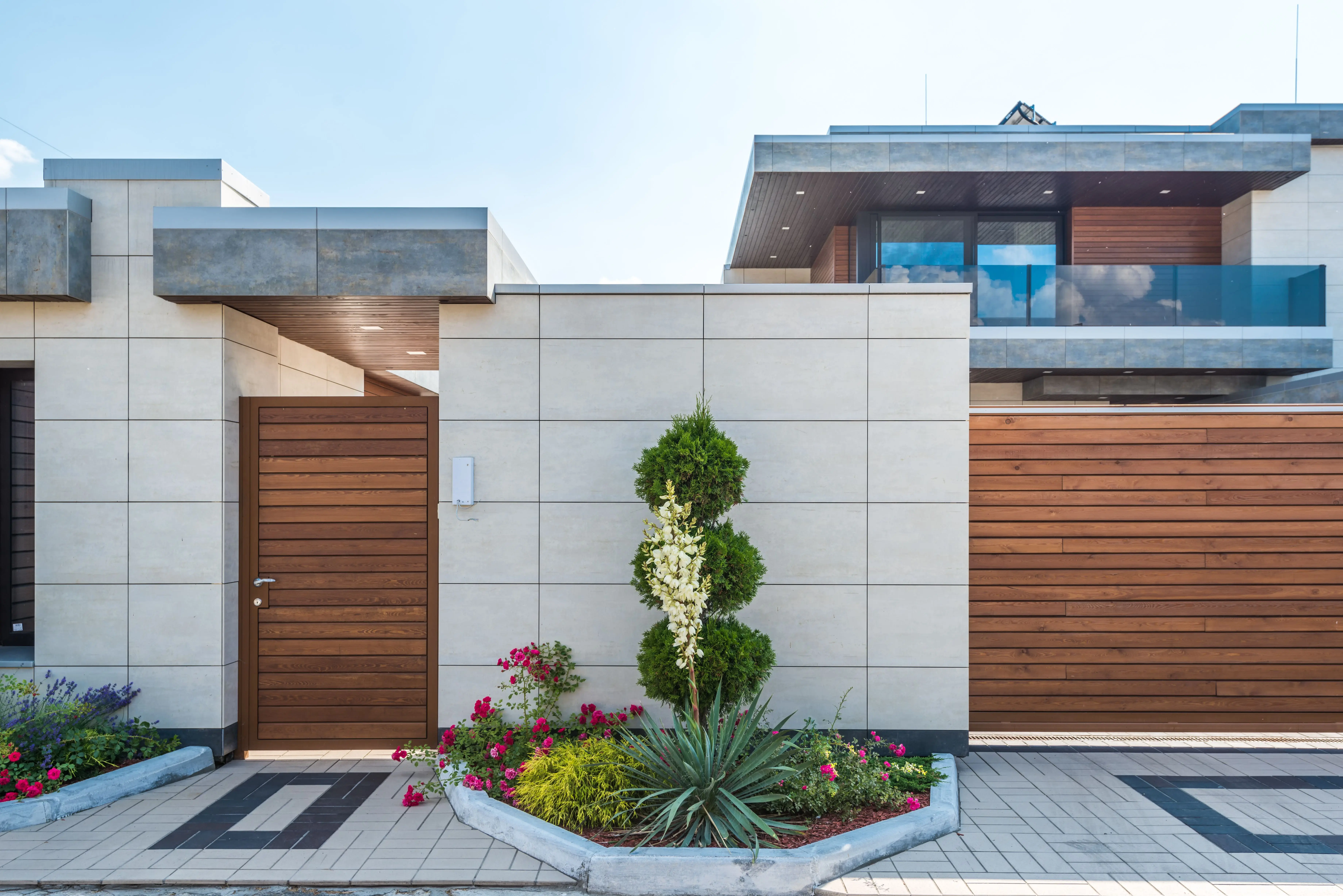 wall lamp outdoor Contemporary house exterior featuring a stylish wooden facade, entrance gate, and vibrant garden.