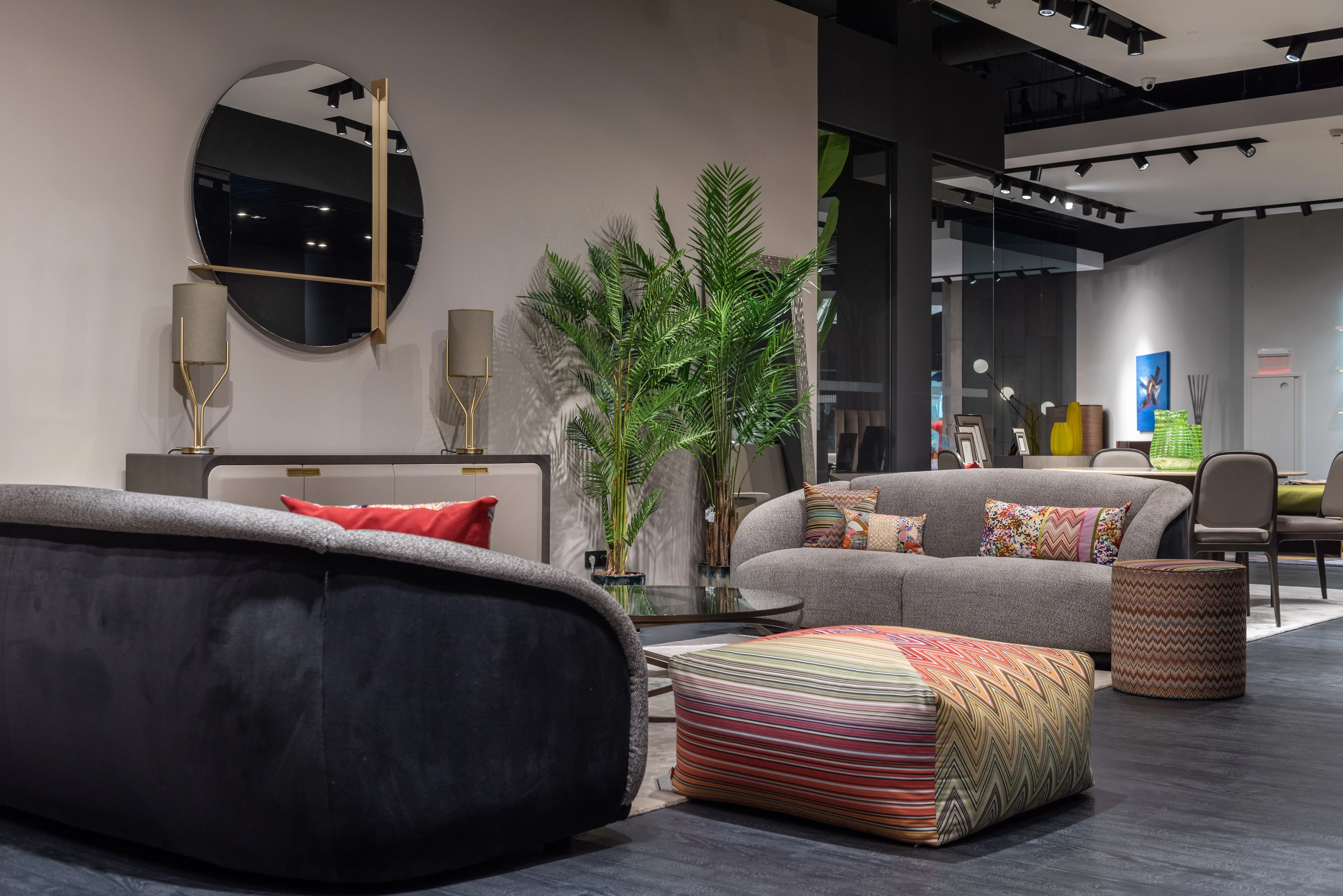 pouf coffee table Interior of modern apartment with soft couches and colorful cushions and poufs placed near wall with mirror and decorations in modern apartment with green plants