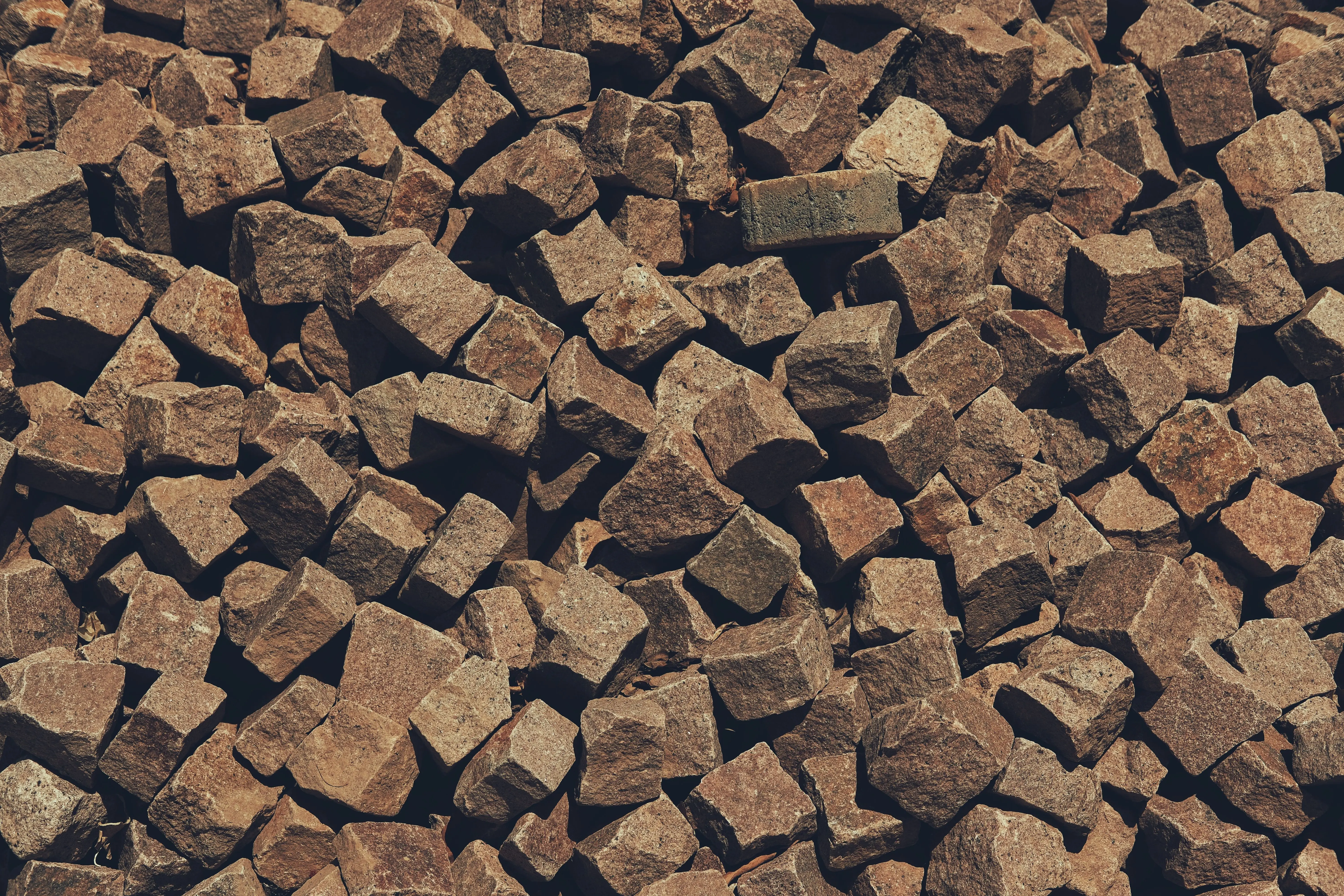 red granite Close-up view of brown cobblestone paving stones in Marrakesh, Morocco, showcasing texture and pattern.