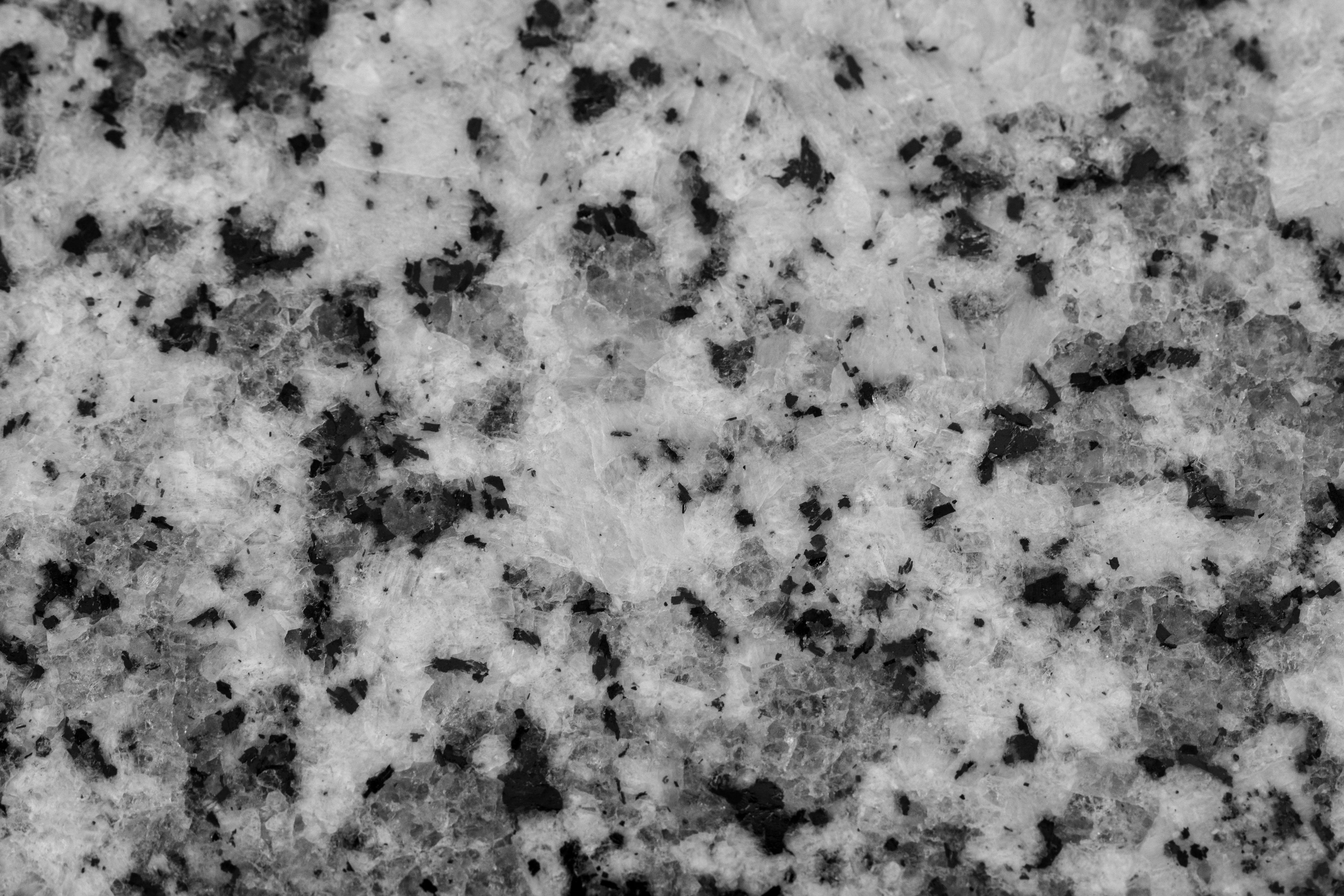 red granite Detailed close-up of a granite surface showcasing its natural texture in black and white contrast.