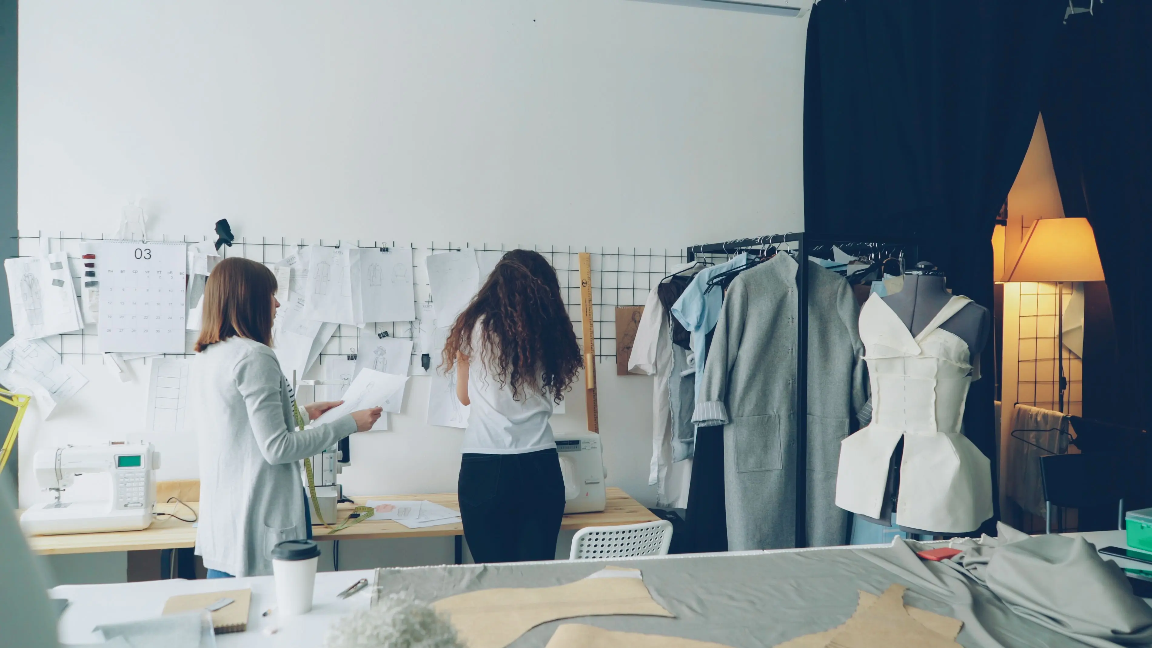 studio room ideas Fashion designers working on clothing sketches and patterns in a modern studio.