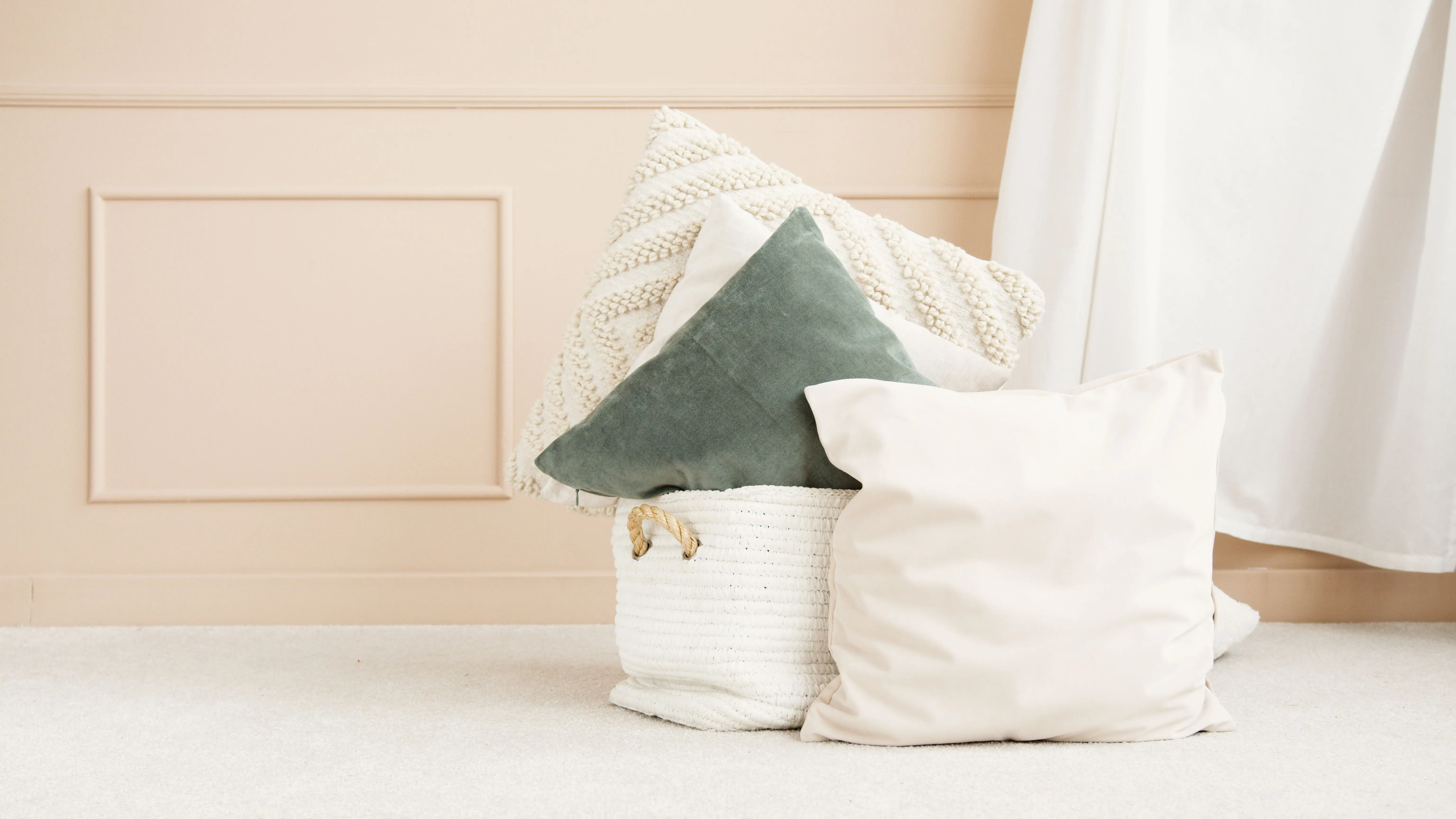 blue decorative pillows A stylish collection of textured cushions against a beige wall, showcasing minimalist elegance.