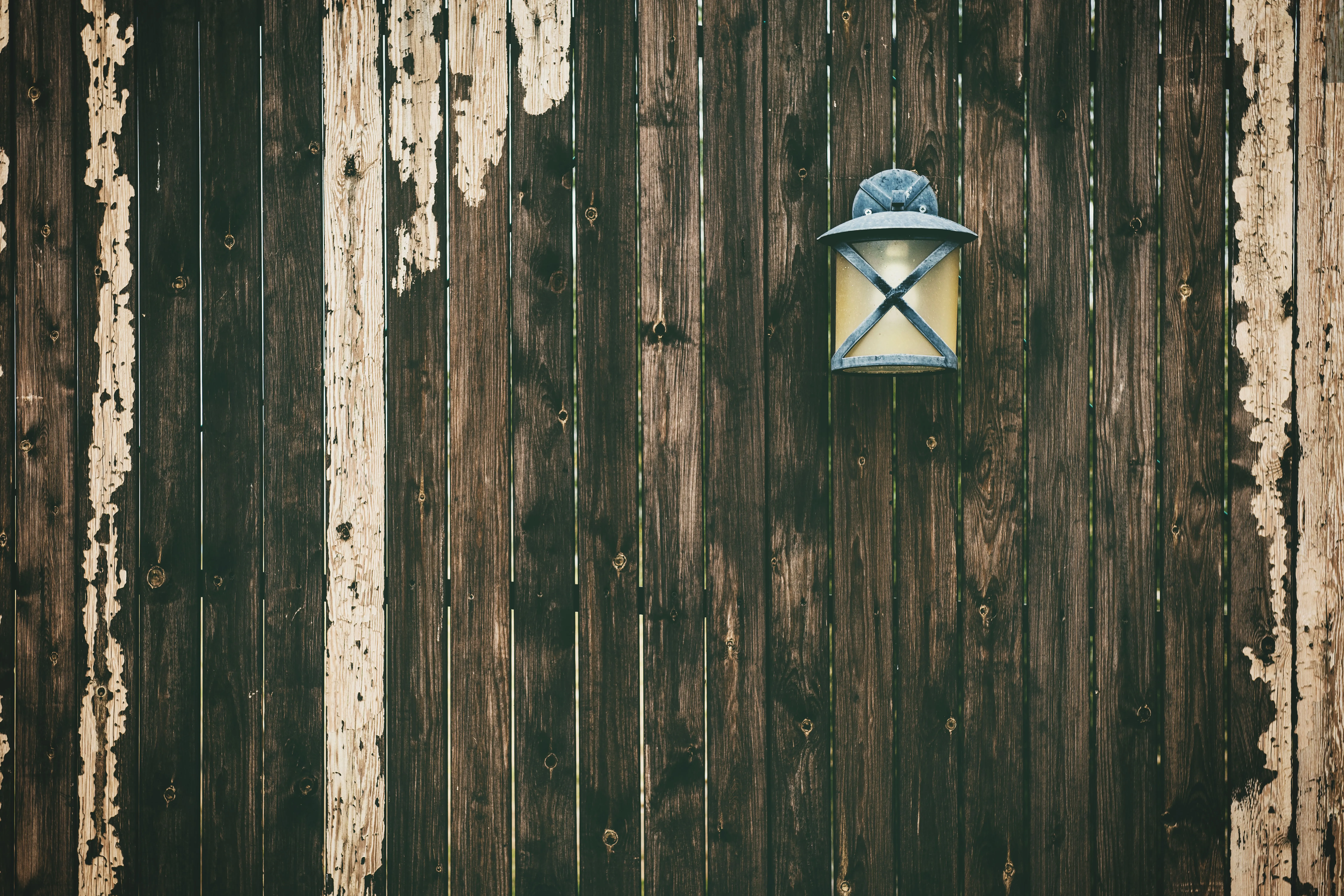 vinyl fence parts A weathered wooden fence with a vintage lantern adding rustic charm.
