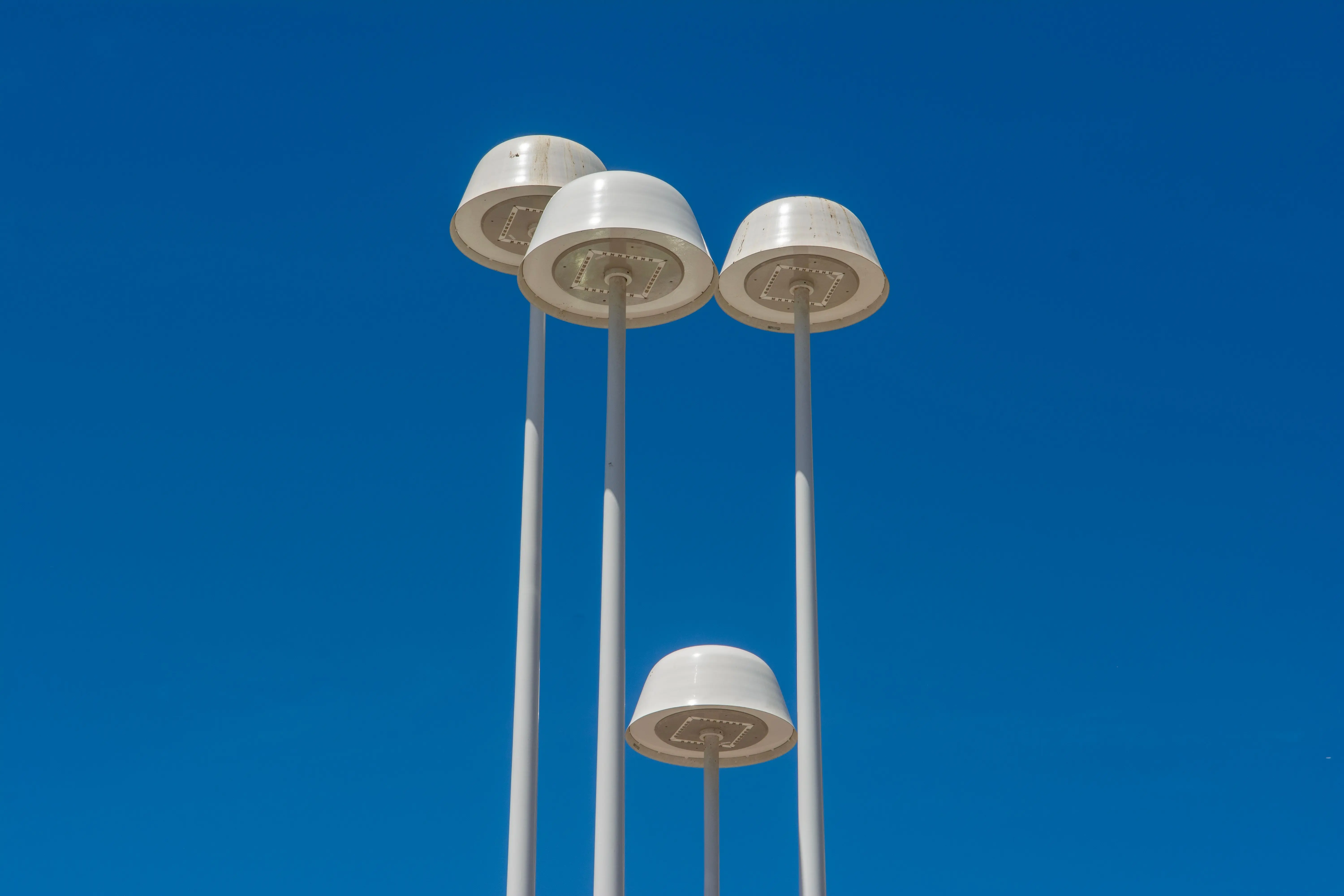 white table lamp Minimalist street lamps set against a blue sky, showcasing urban design and architecture.