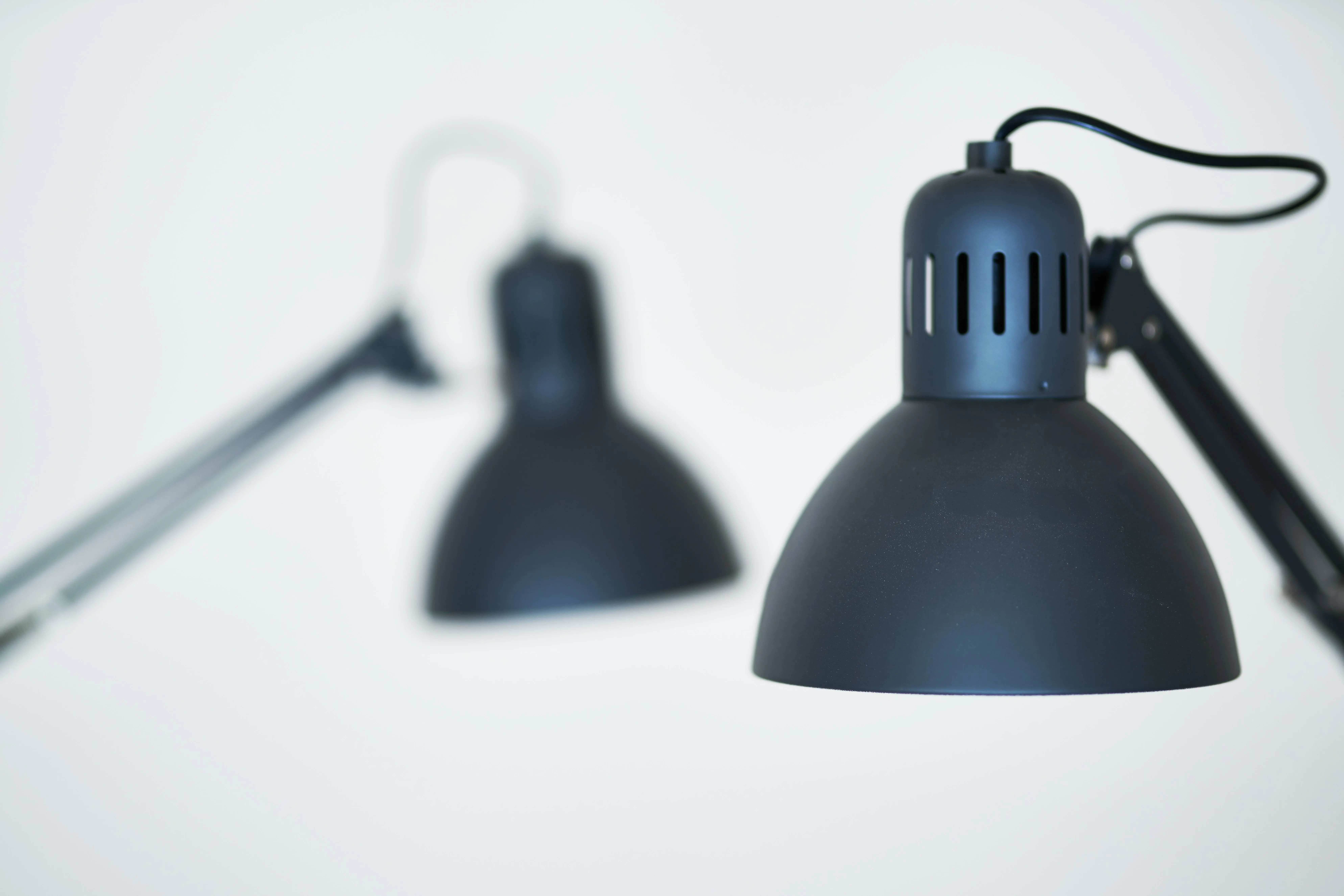 white table lamp Minimalist close-up of contemporary black desk lamps in a studio setting.