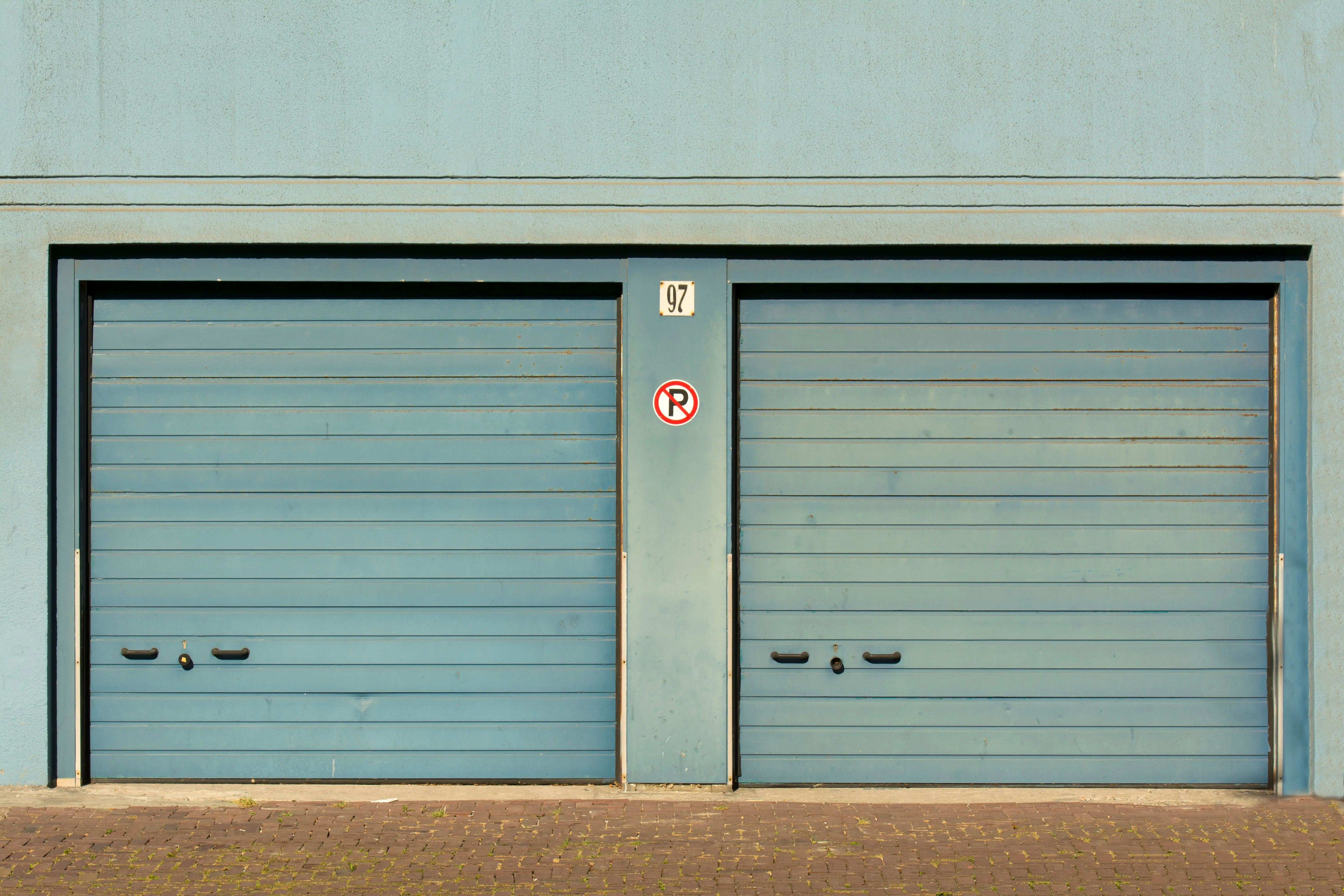 9x7 garage door Blue garage doors with a no parking sign painted outdoors.