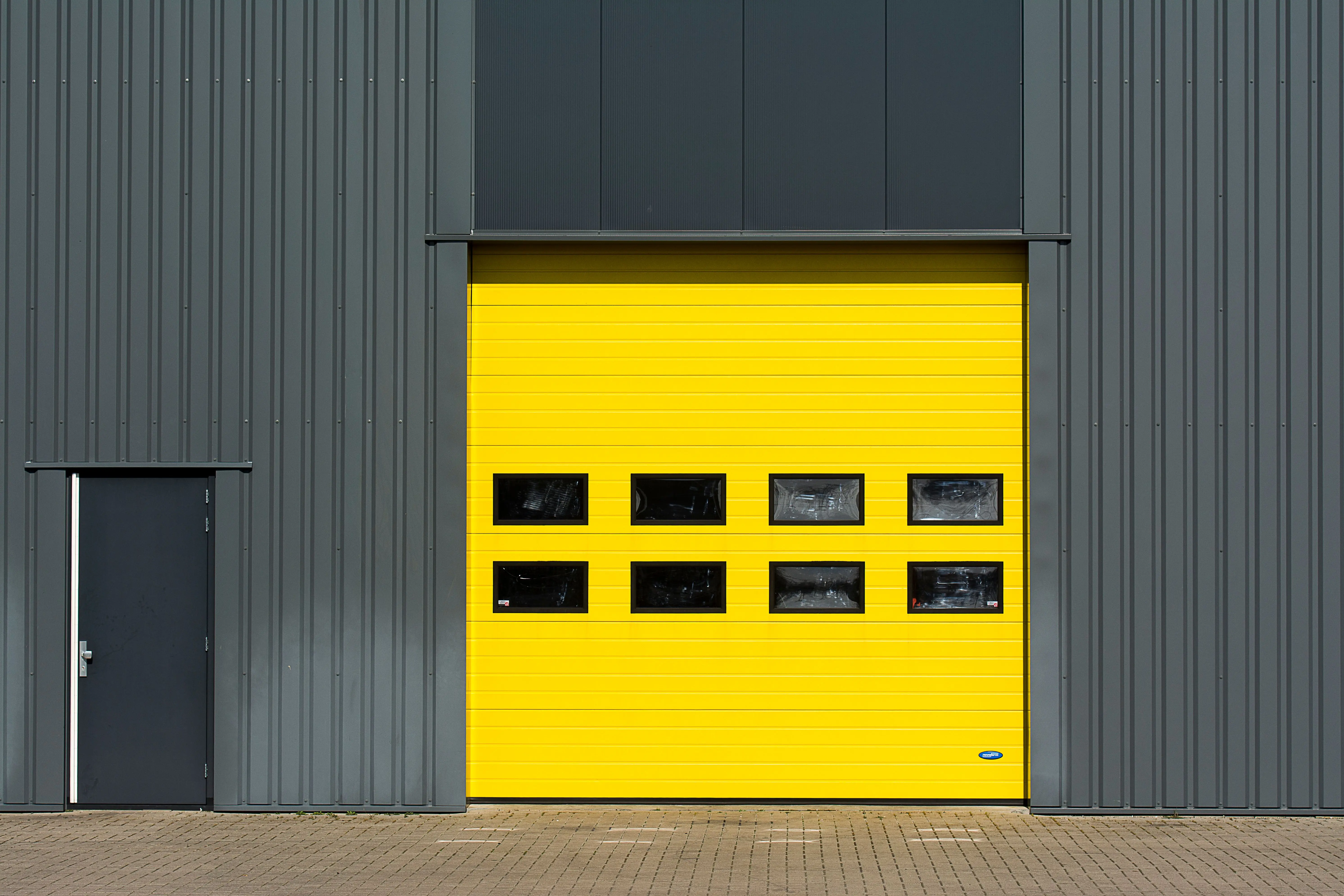 9x7 garage door A sleek industrial structure featuring a vibrant yellow garage door for architectural interest.