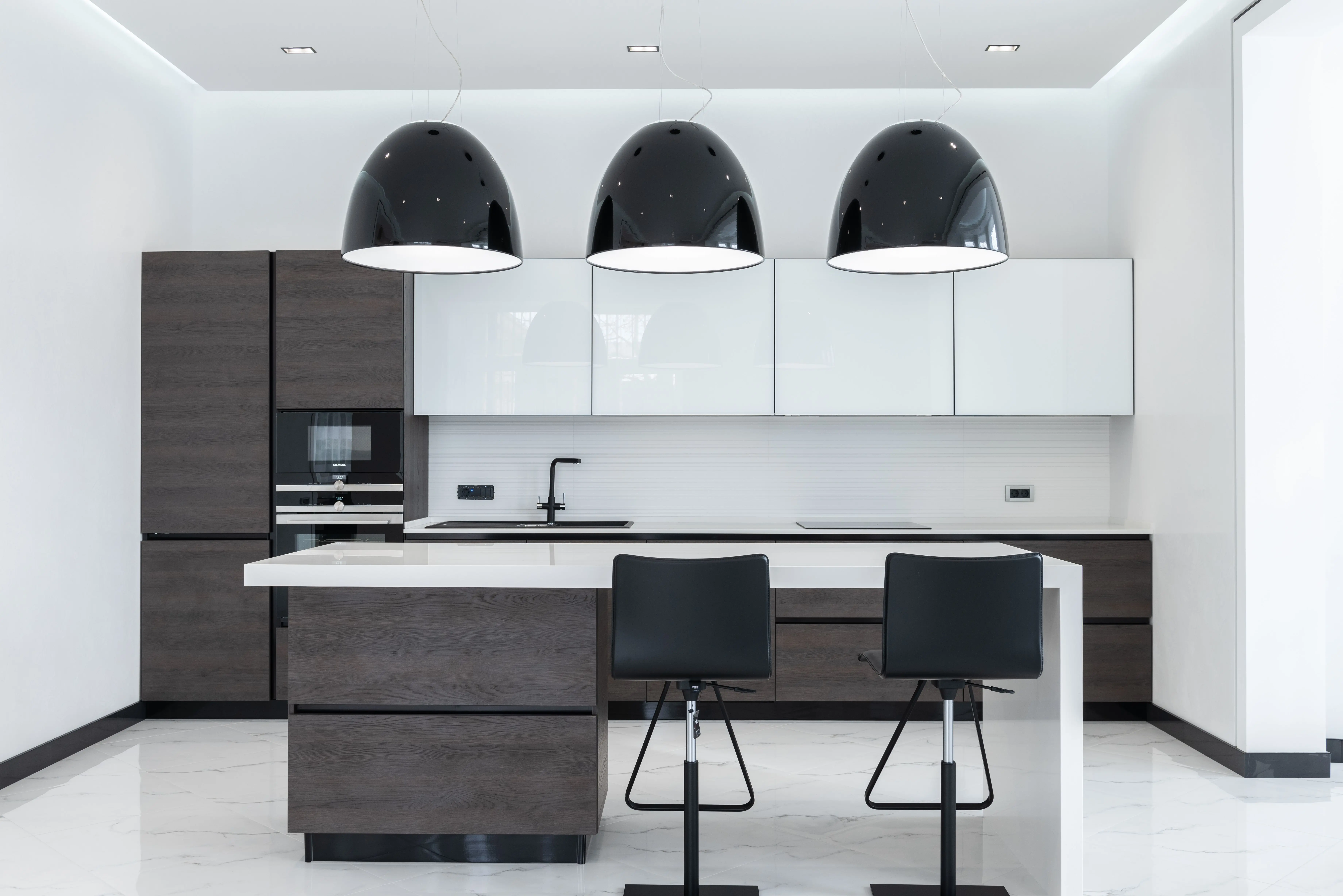 mdf cabinets Creative lamps hanging over table with chairs in spacious kitchen with modern furniture and appliances