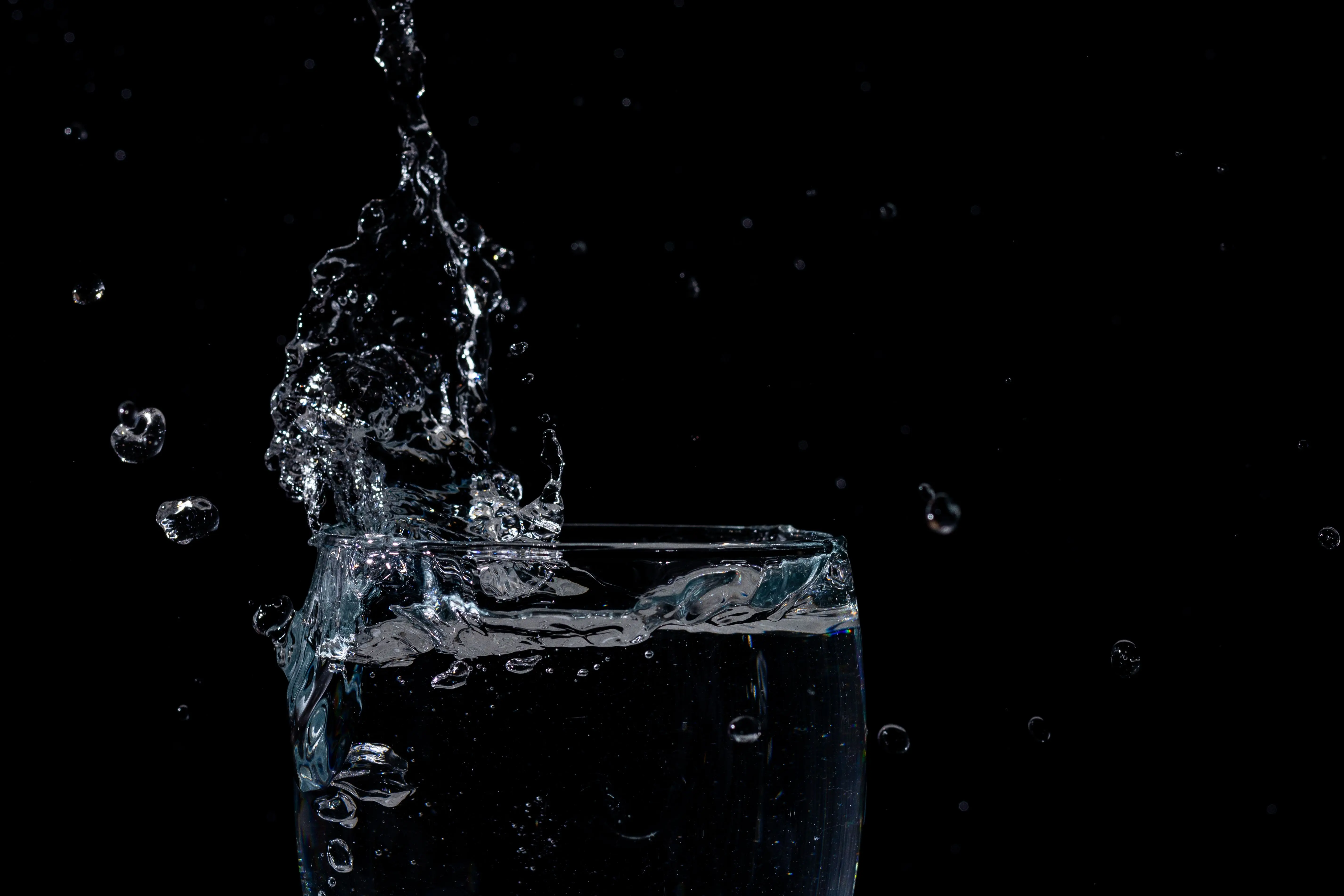 mdf cabinets Close-up of water splashing in a glass against a black background.