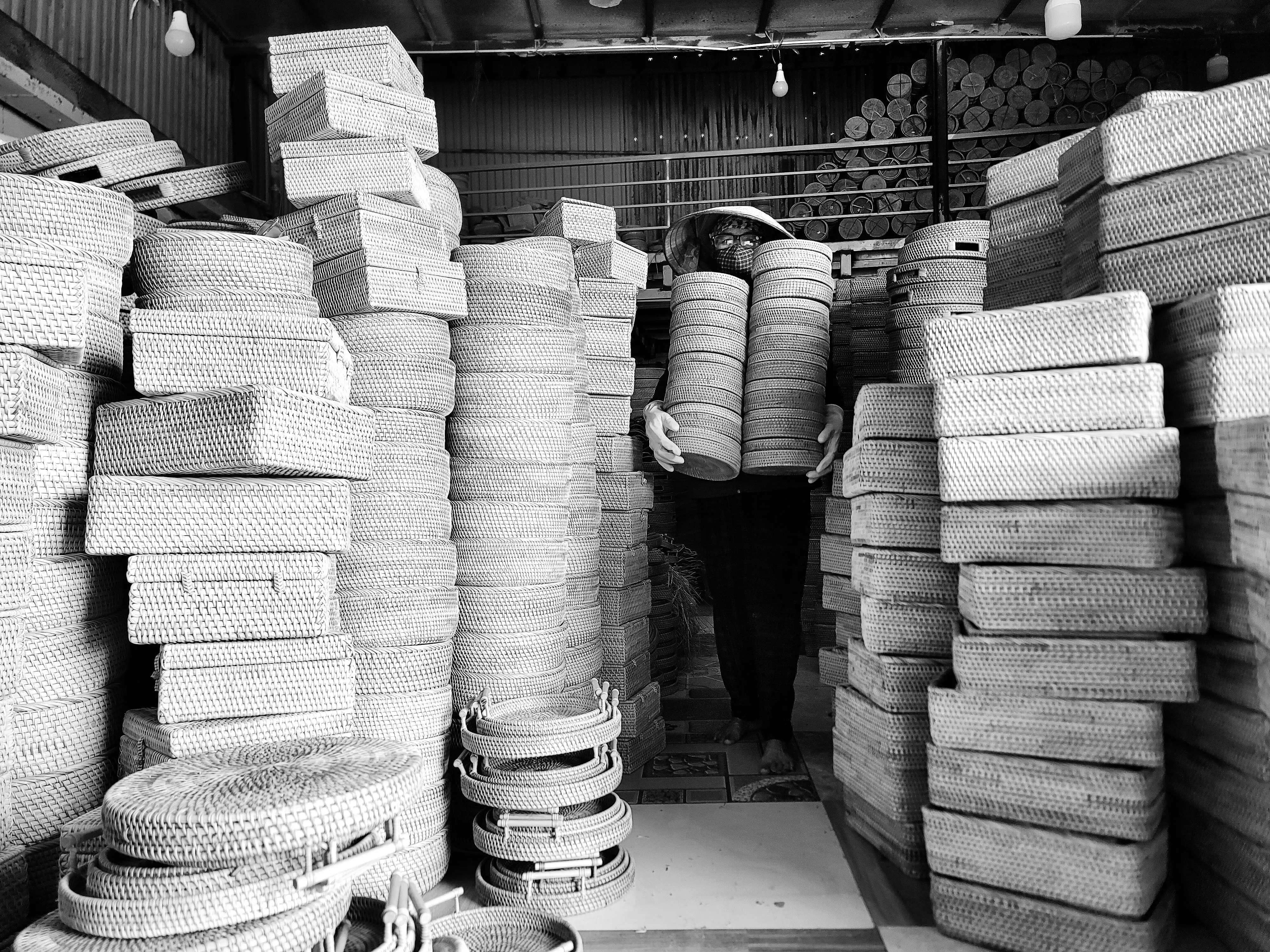 large baskets A craftsman in a Hà Nội workshop surrounded by traditional woven bamboo baskets.