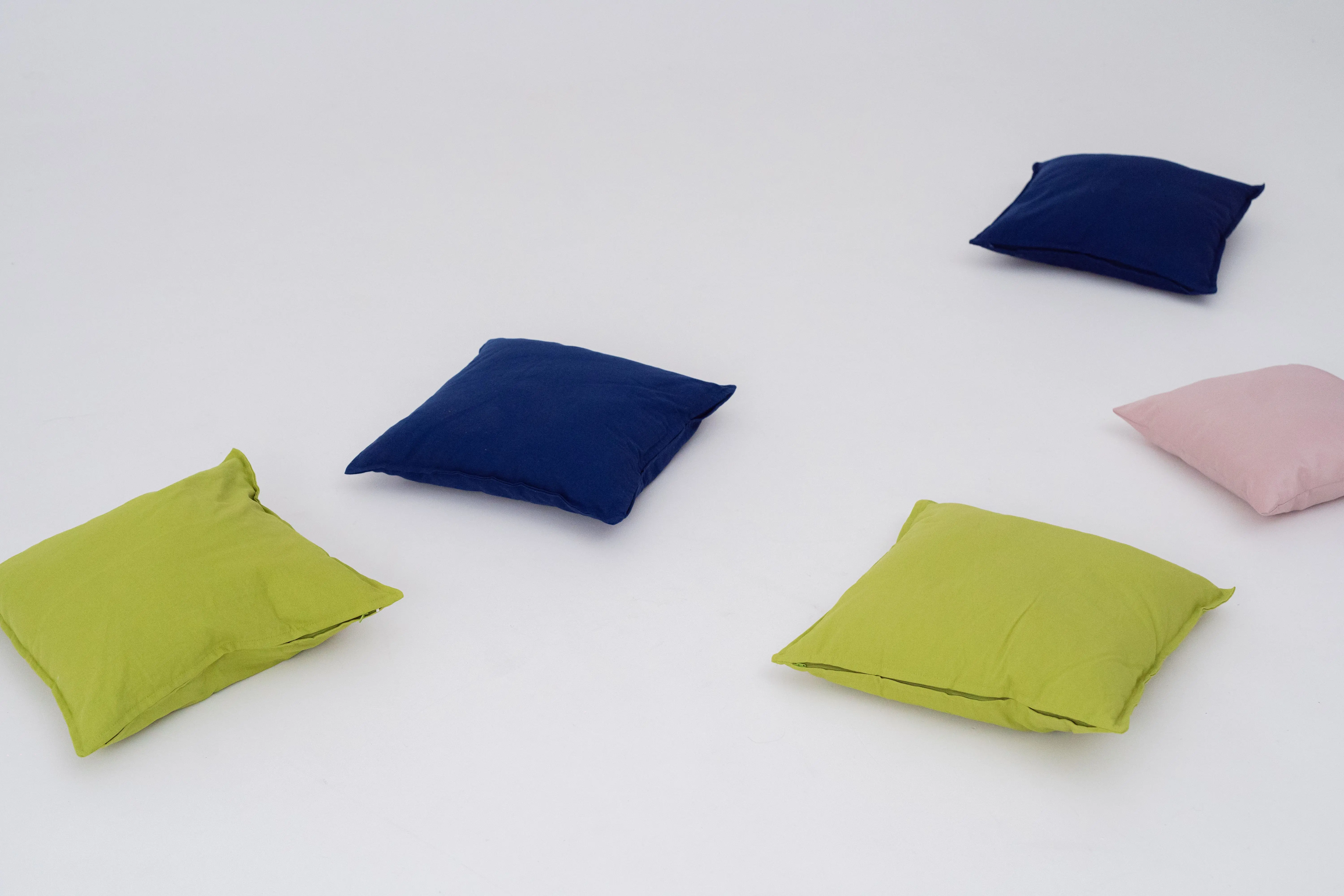 light blue throw pillows Vibrant green, blue, and pink throw pillows spread on a white background.