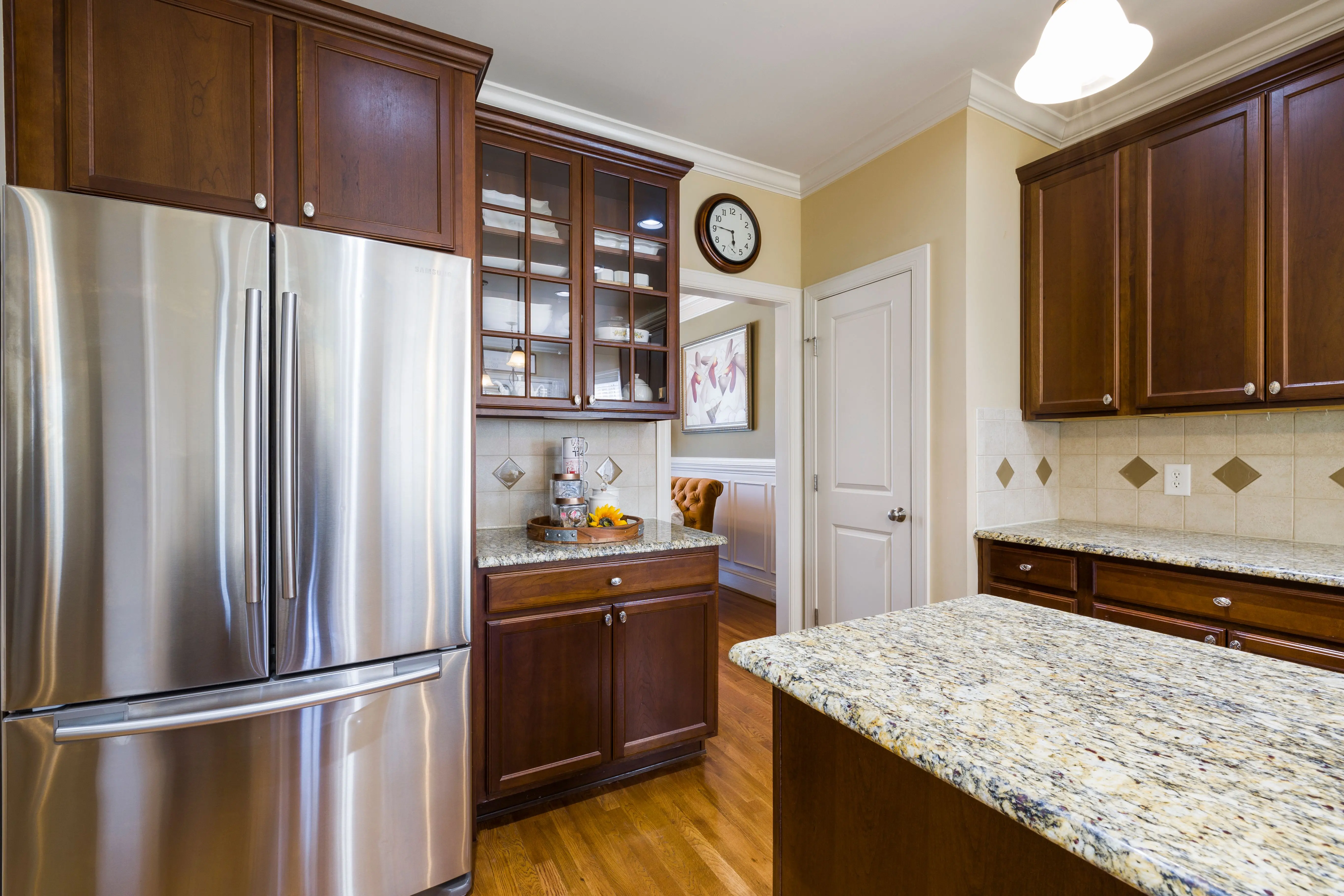 cherry wood cabinets Spacious kitchen featuring stainless steel appliances and elegant wood cabinetry with granite countertops.