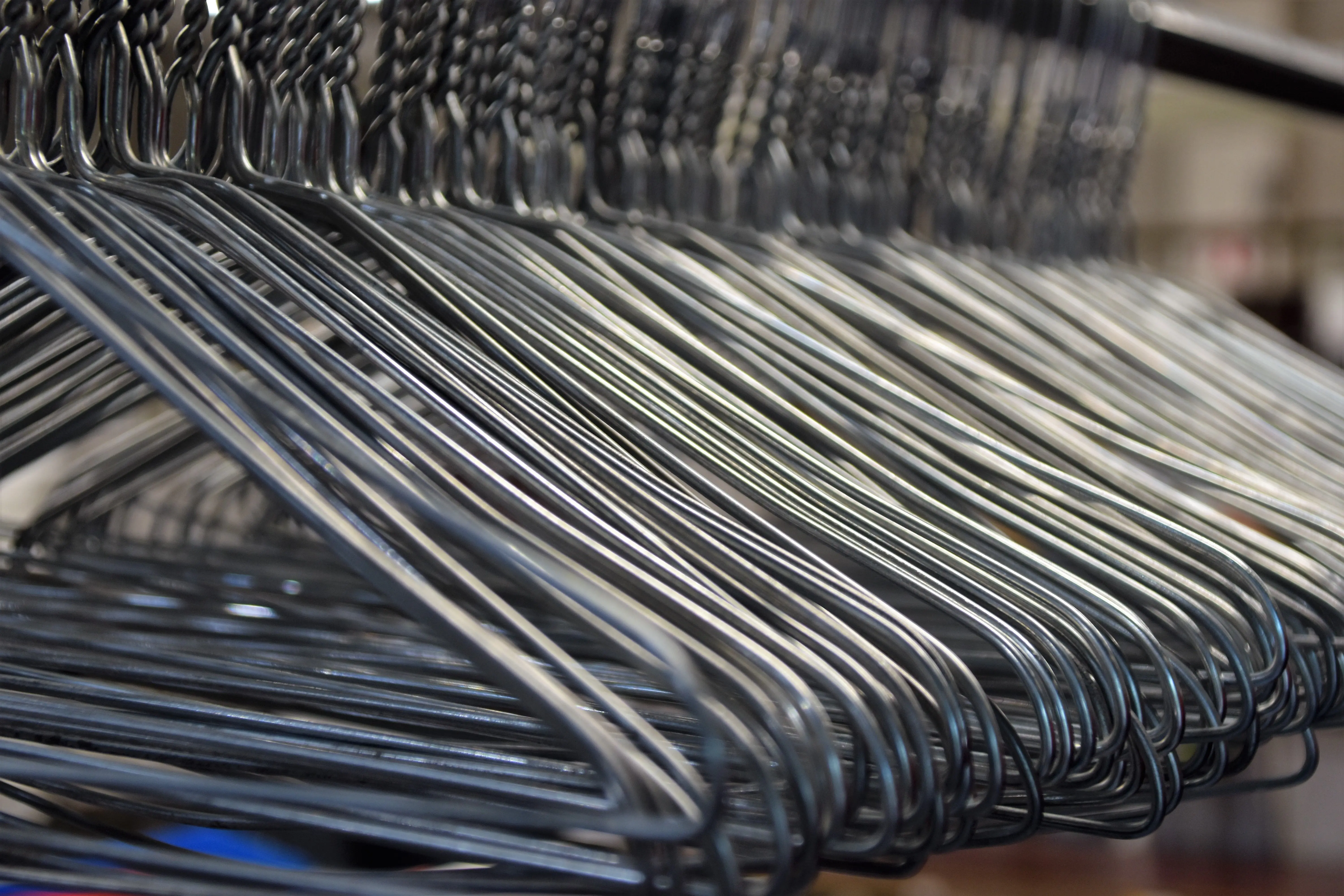 heavy duty closet rod Closeup of set of metal hangers for clothes hanging on rod on blur background in daytime
