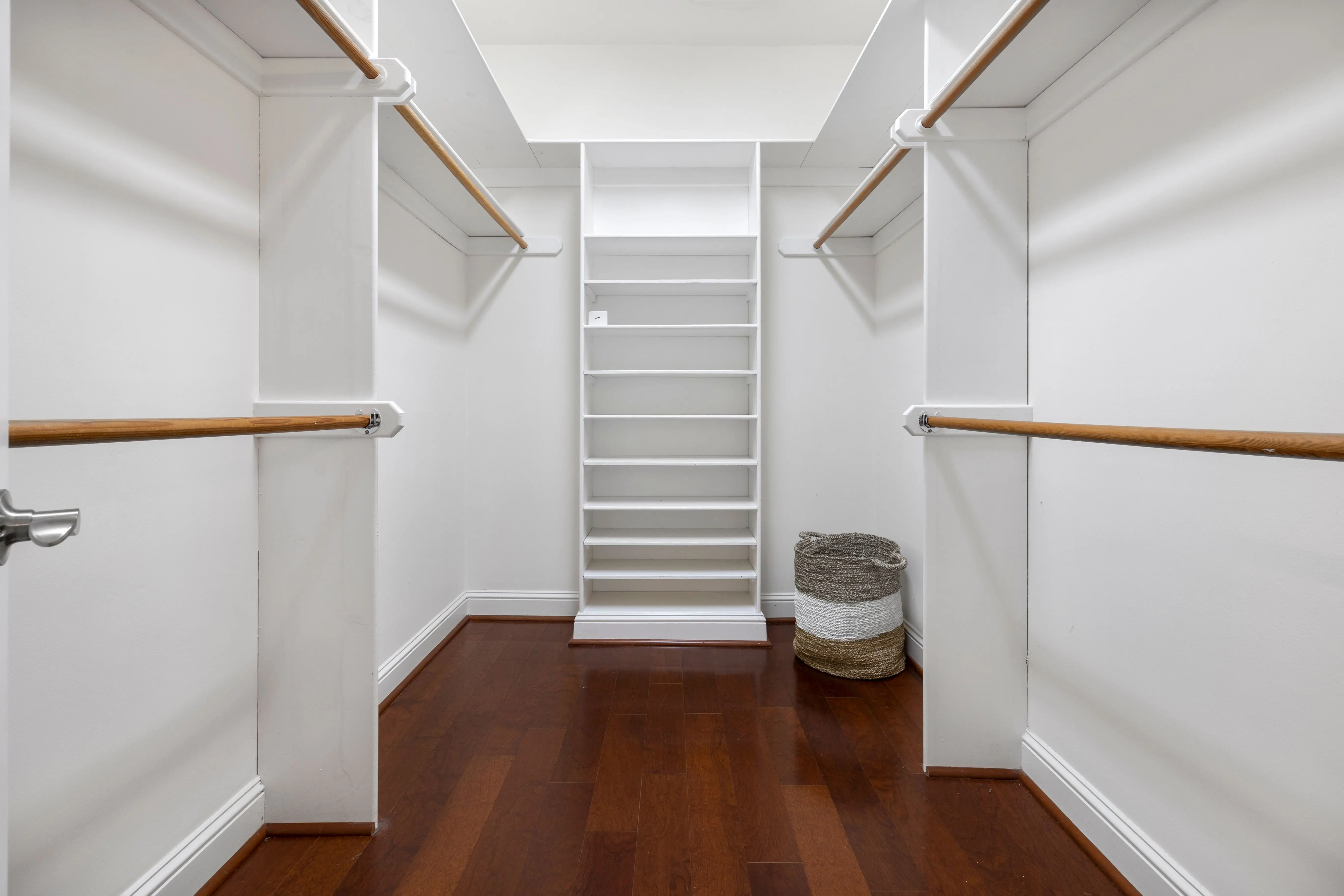 heavy duty closet rod Minimalist empty walk-in closet featuring wooden floors, shelves, and hanging rods.