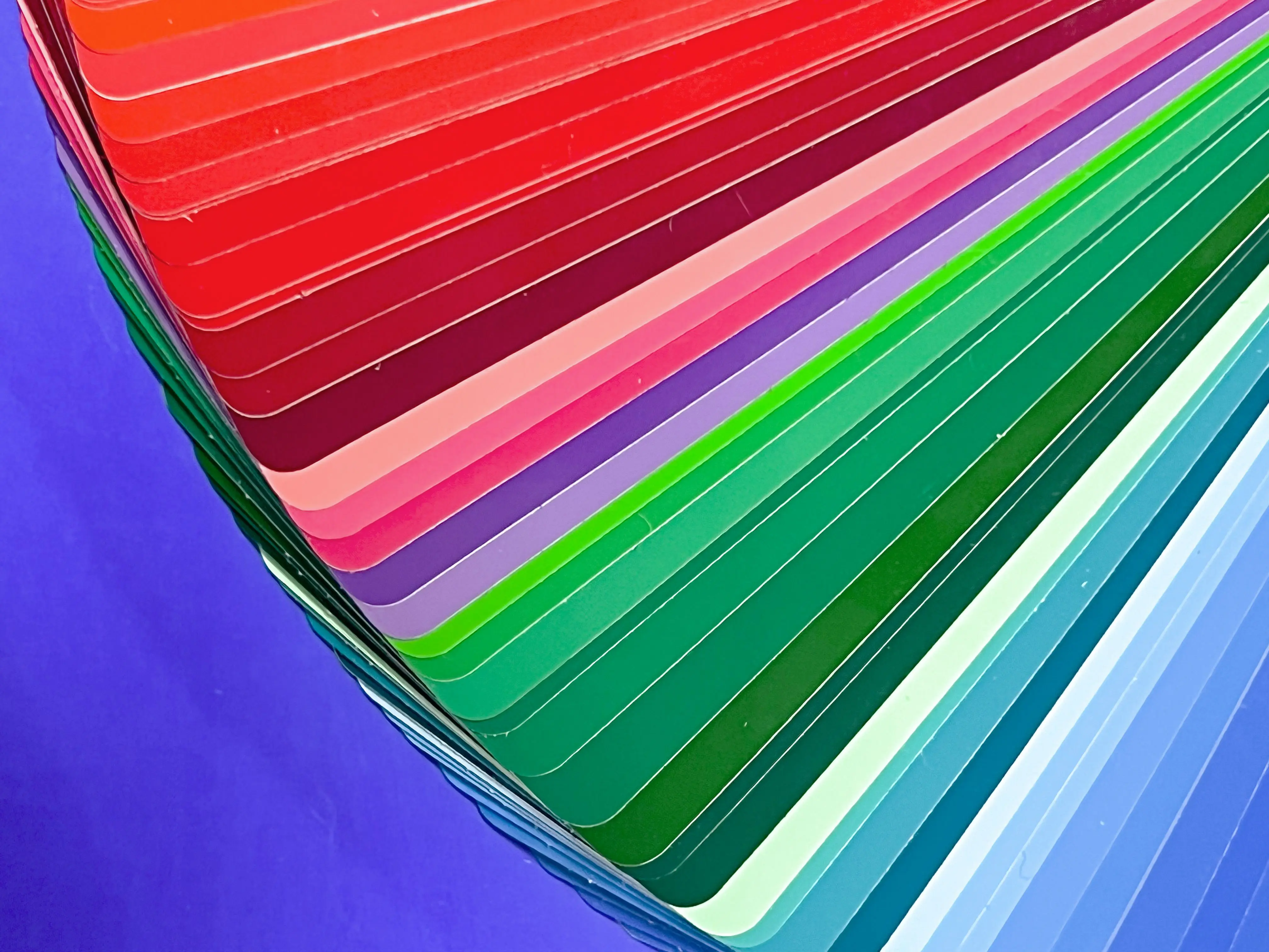 patio paint A bright and vivid fan of colorful swatches arranged in a flat lay on a purple background.