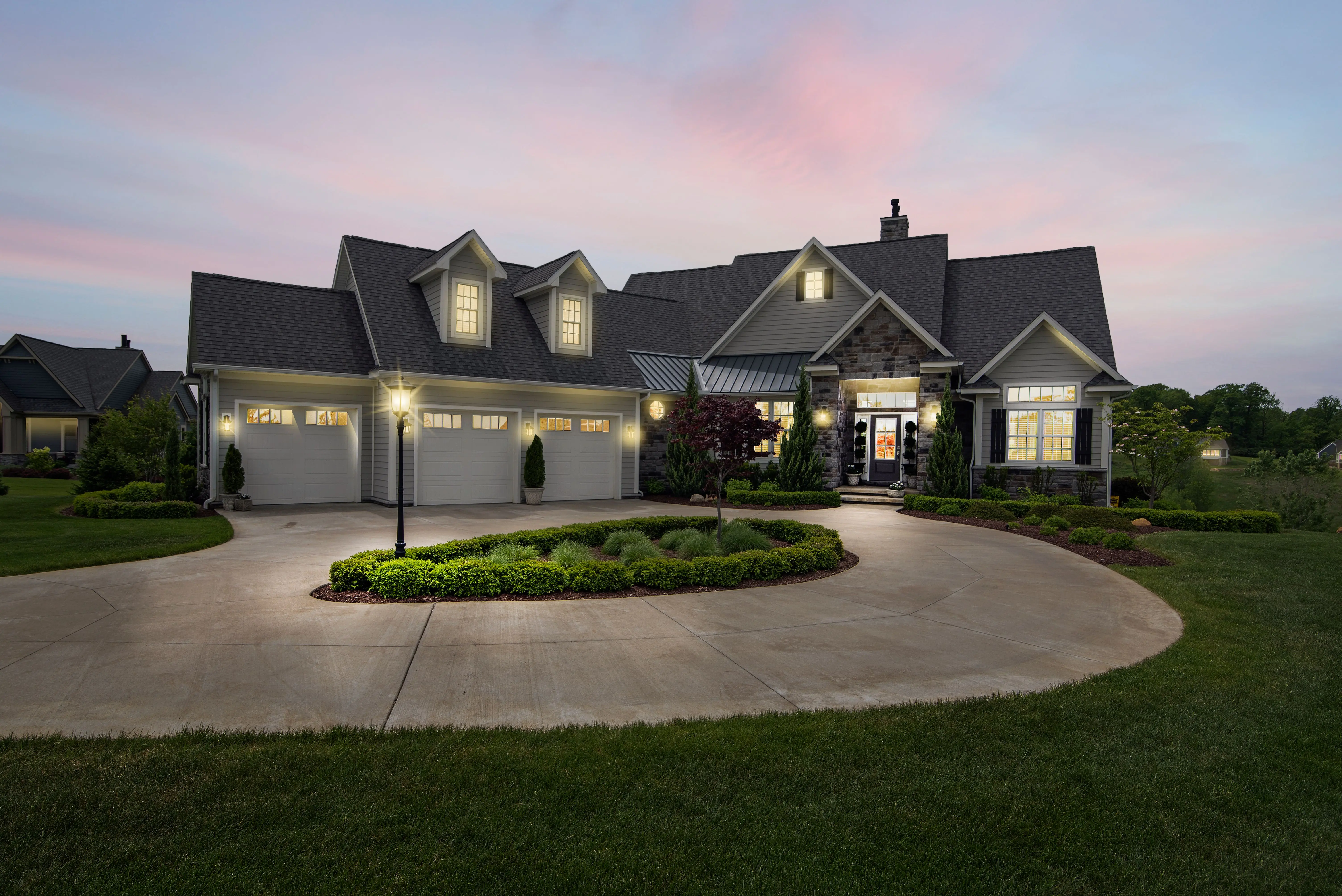 outdoor sconce lights A modern suburban home at dusk, beautifully lit with exterior lights.
