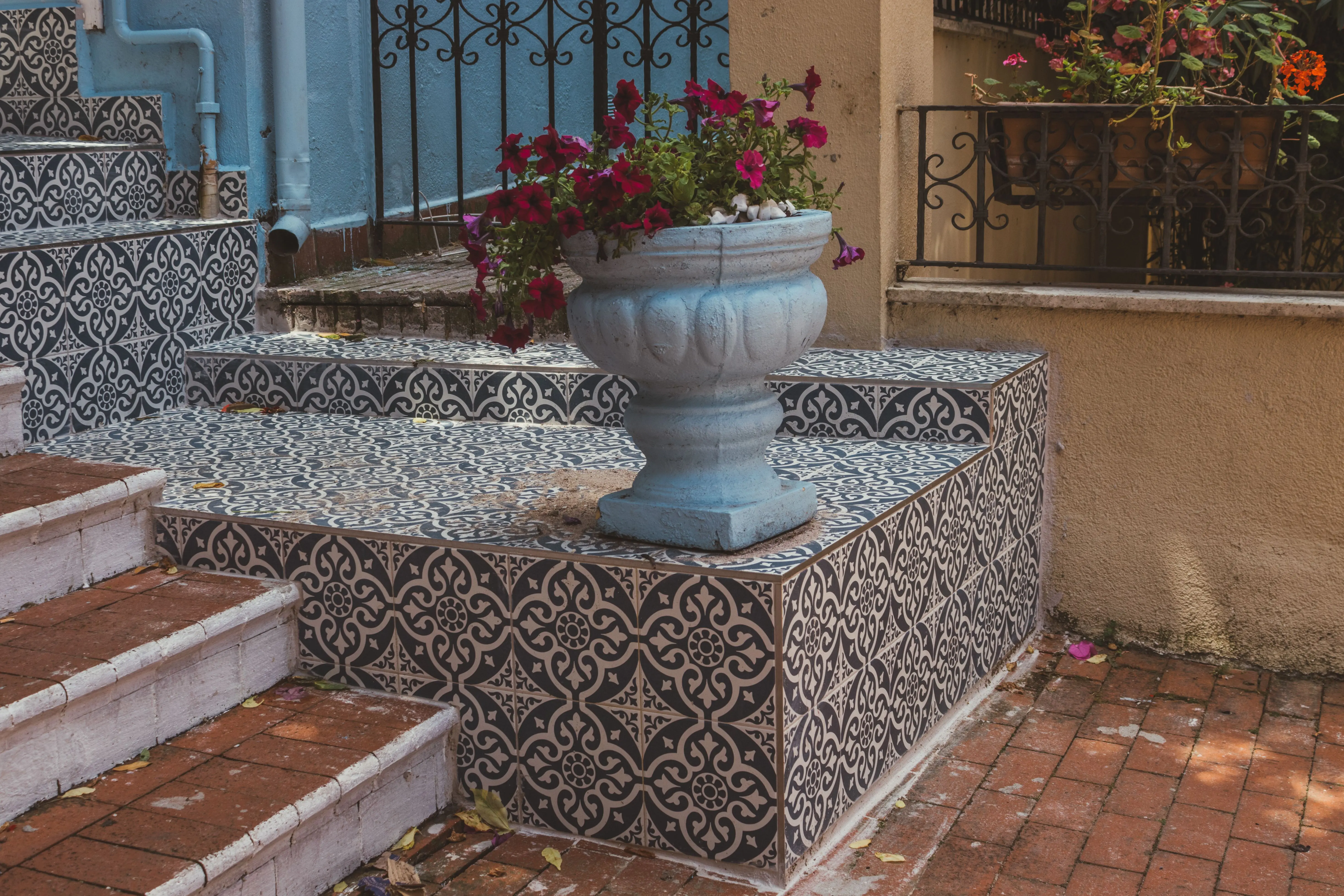 paver patterns Artistic outdoor staircase with intricate tile designs and a flower pot.