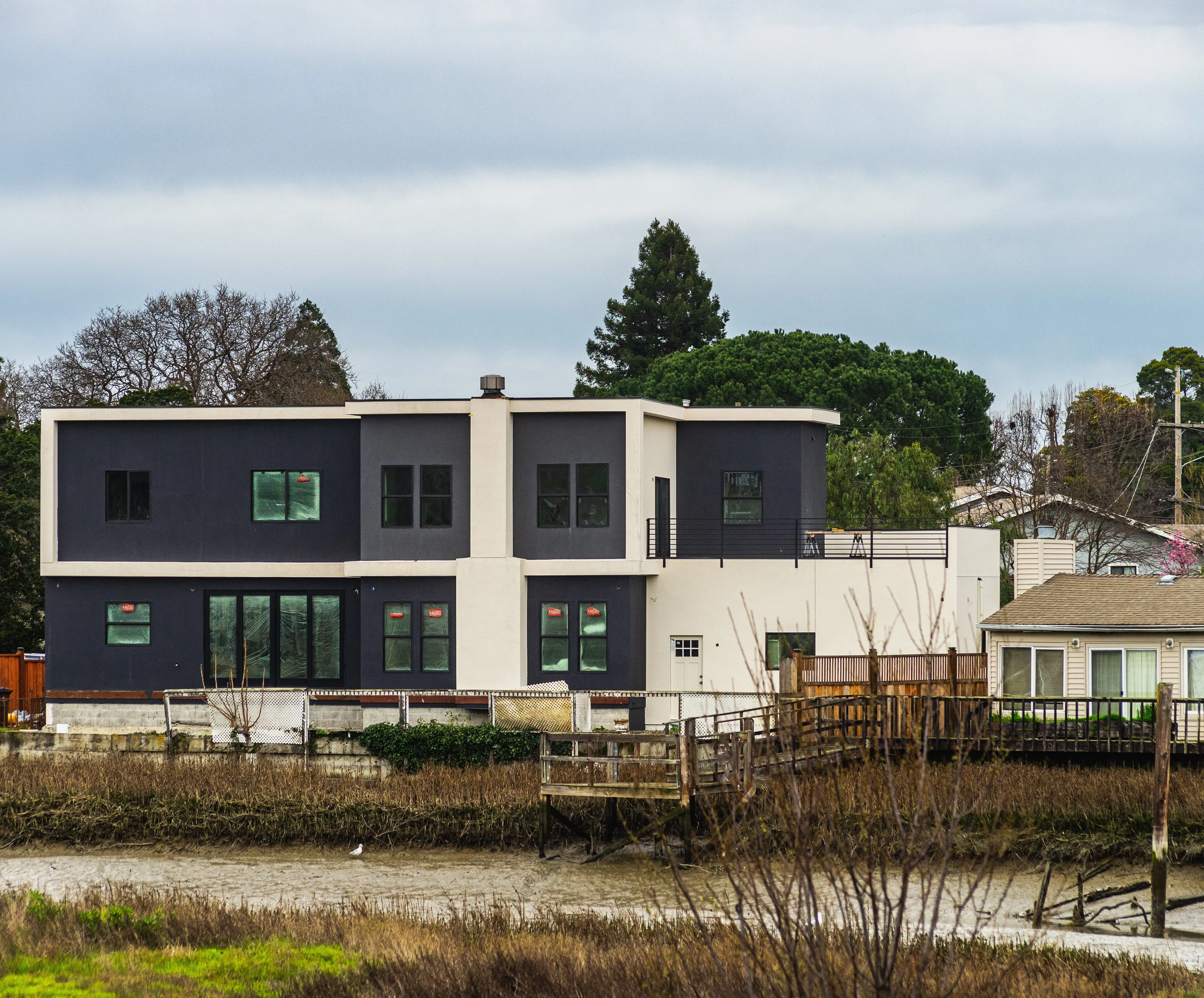 house addition cost Contemporary two-story house near river with fresh architecture.