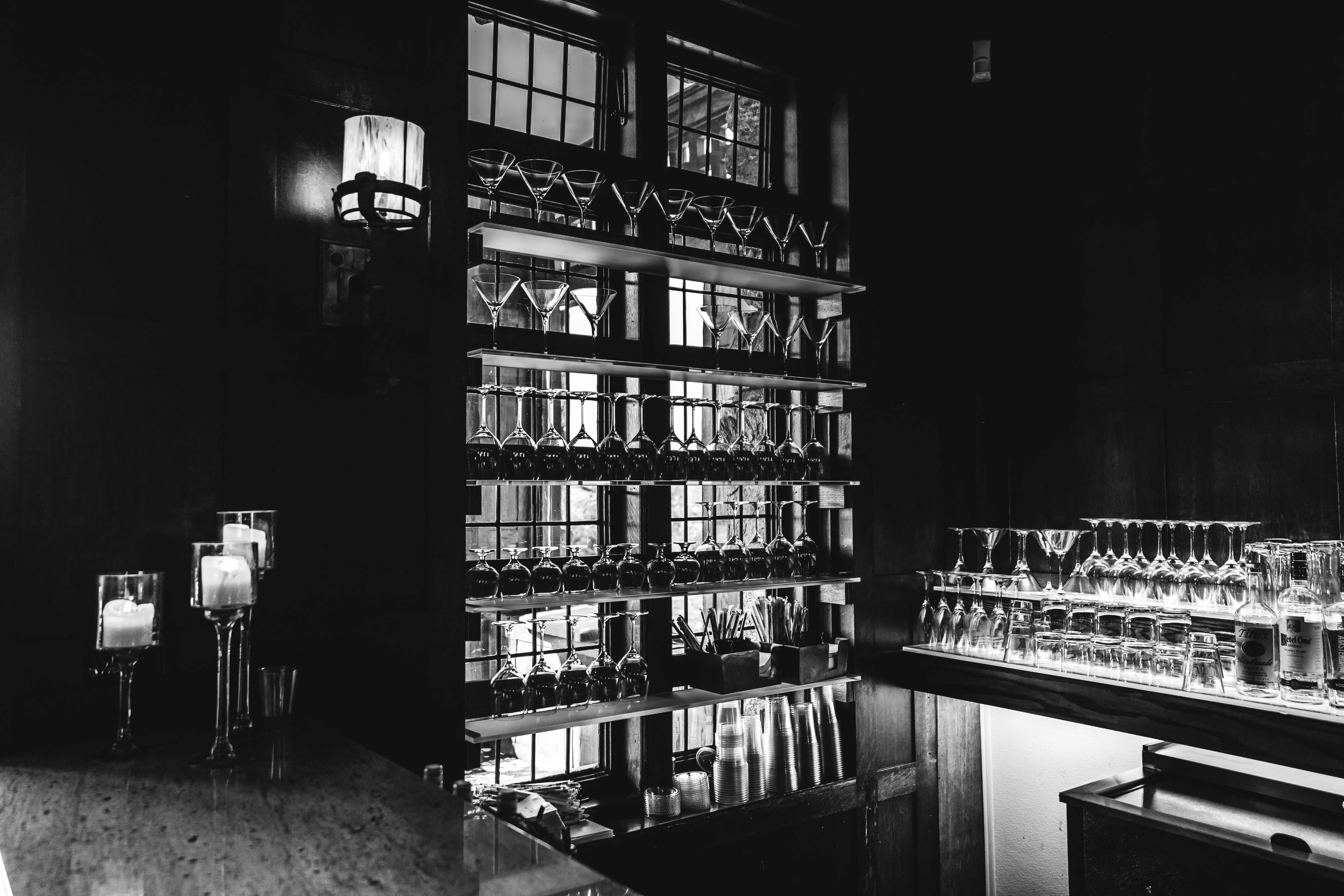 glassware storage containers Sophisticated bar interior featuring shelves of elegant glassware in a moody, black and white setting.