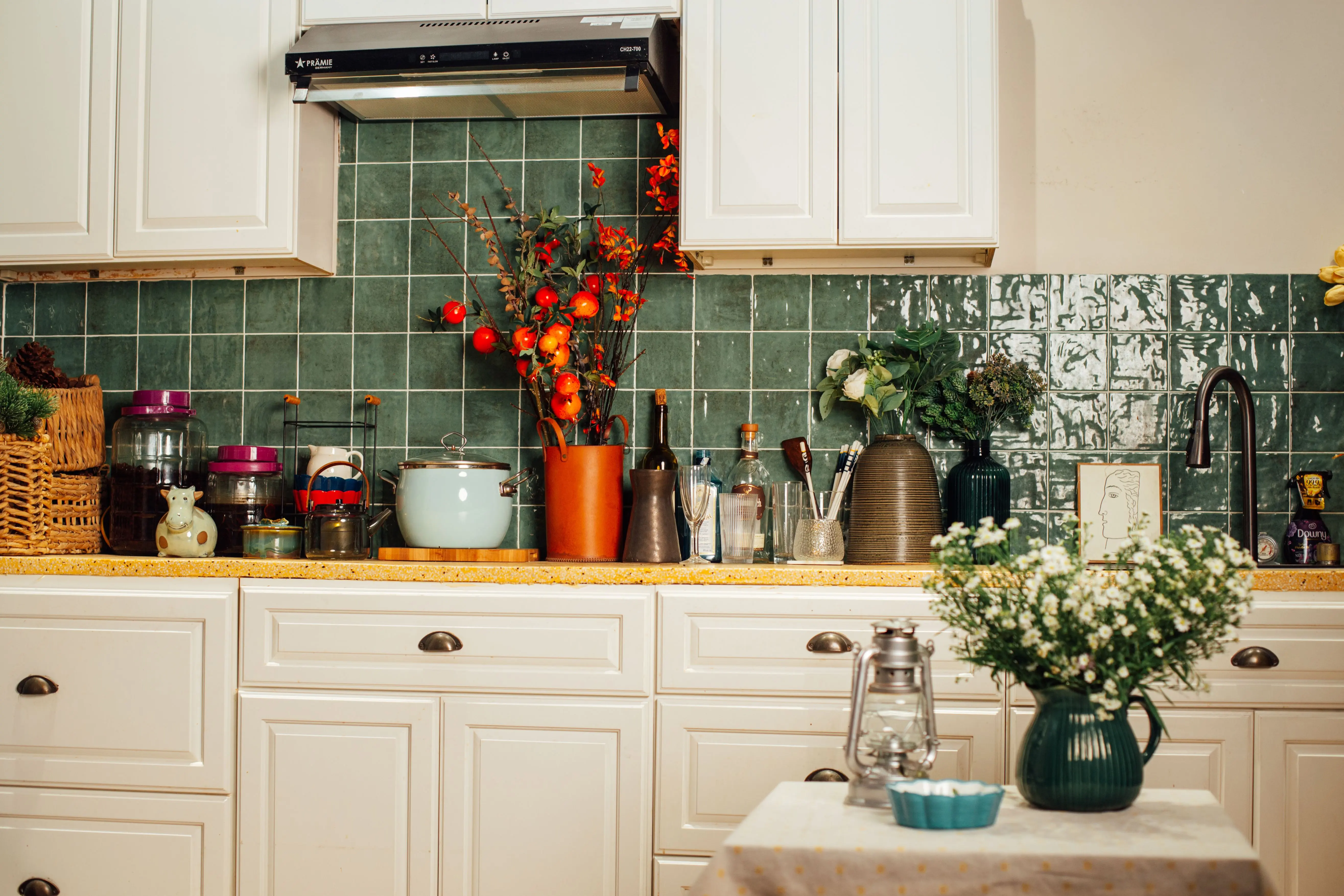 green shower tile A warm kitchen interior featuring a green tiled backsplash and various kitchenware for a homely feel.