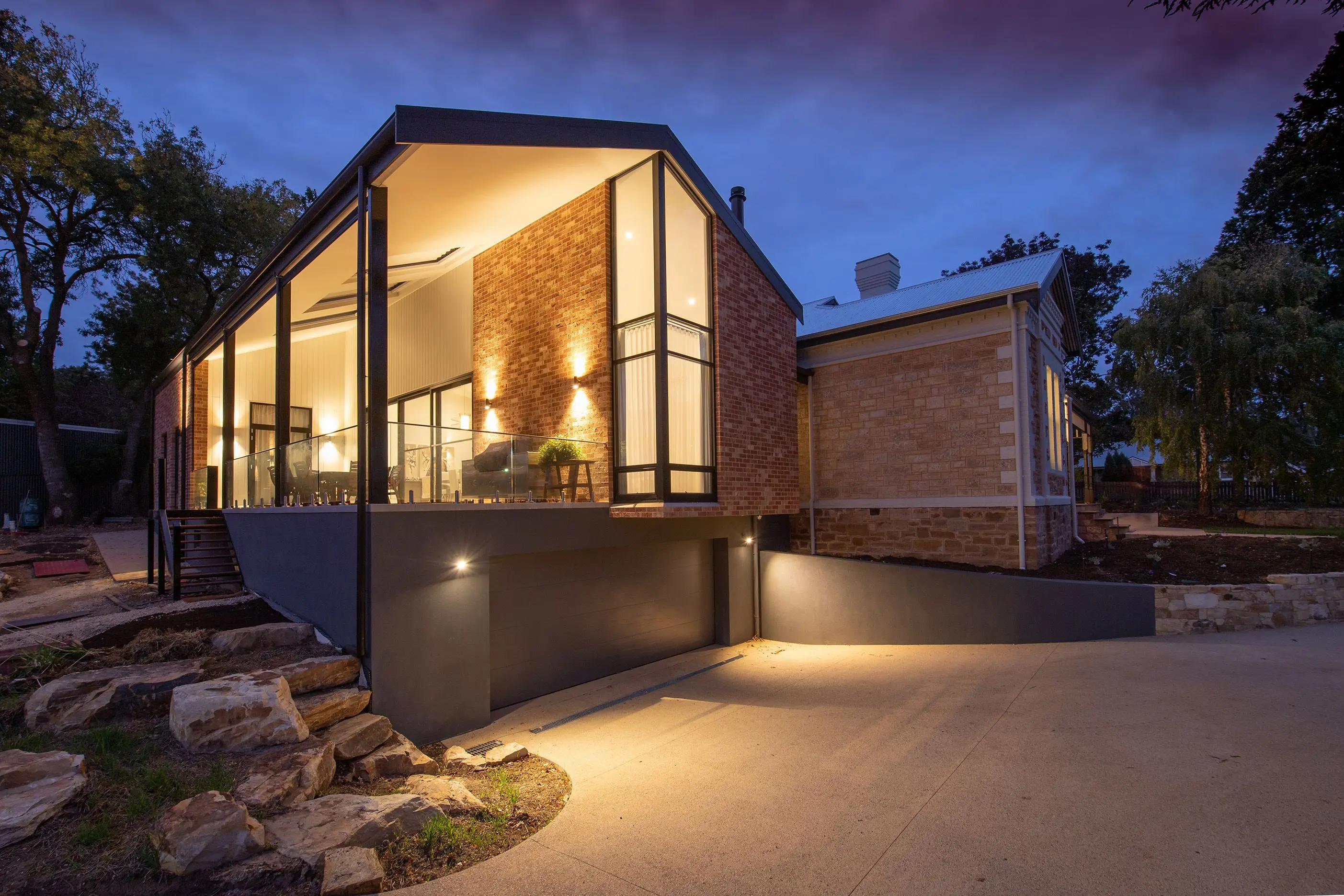 outdoor sconce lights Contemporary residential cottage exterior with shiny lamps near walkway under sky in twilight