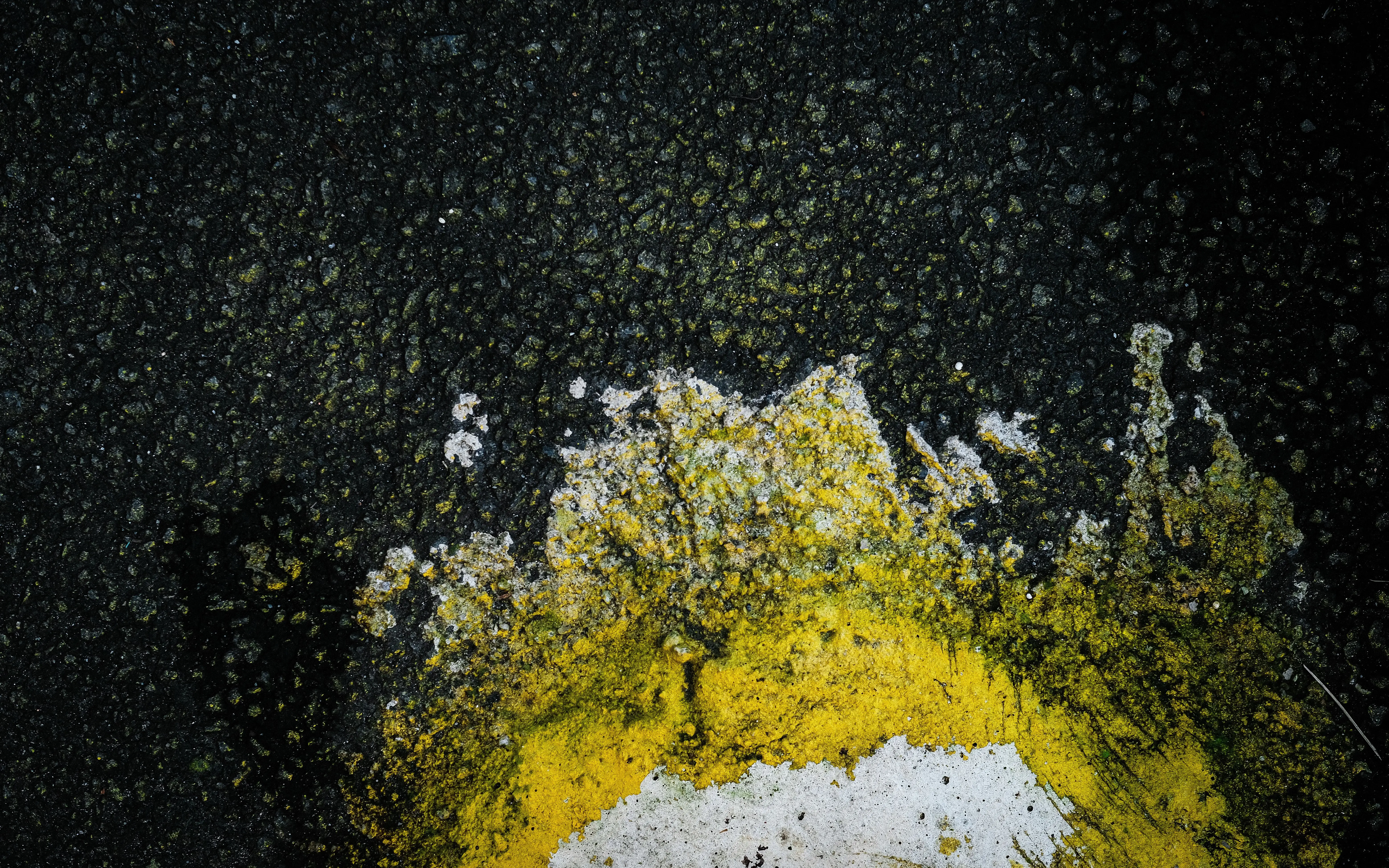 patio paint Close-up of worn asphalt surface with vibrant yellow paint in Jakarta, Indonesia.