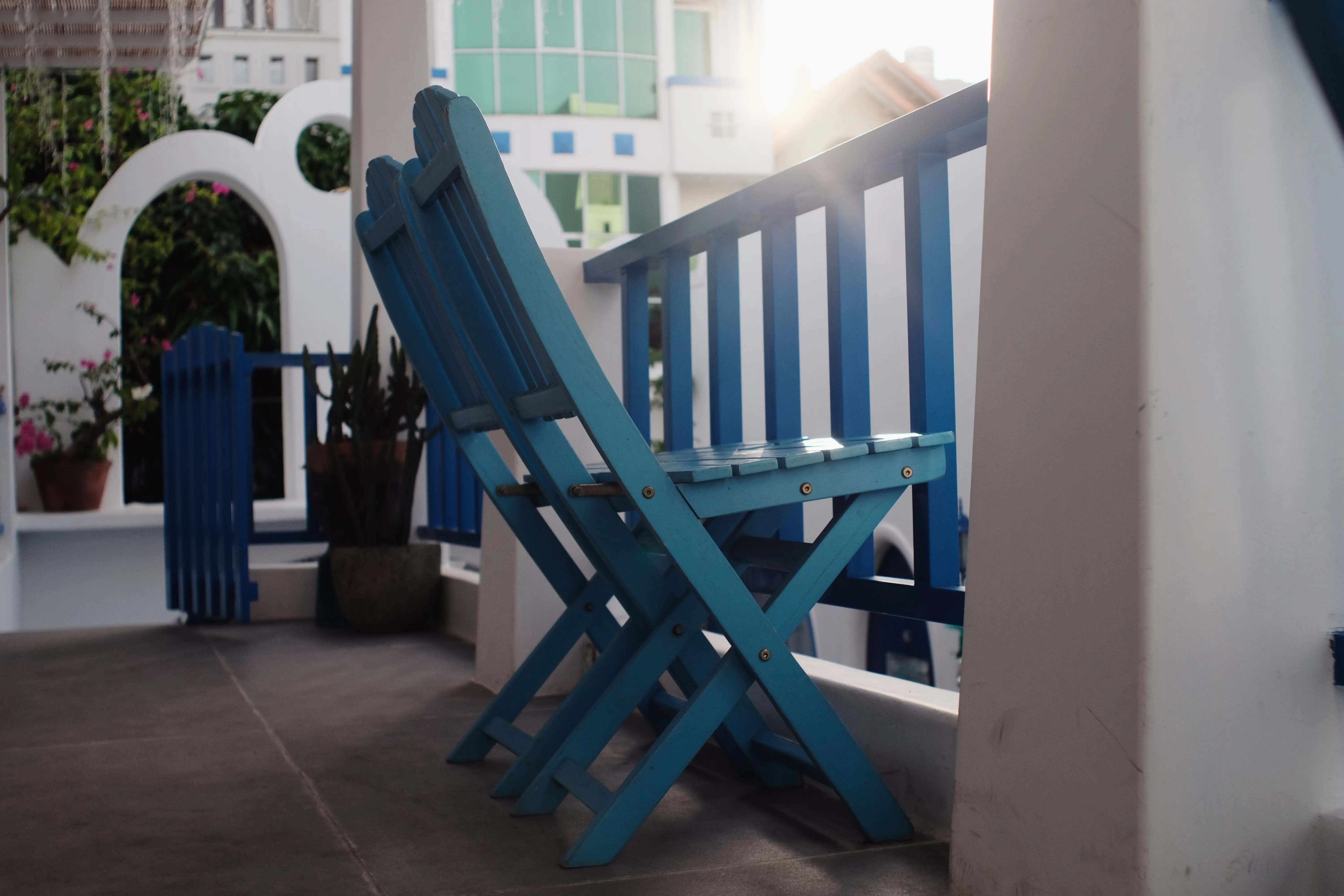 patio paint Stylish blue wooden chairs on a bright porch, perfect for relaxation and sunny ambiance.