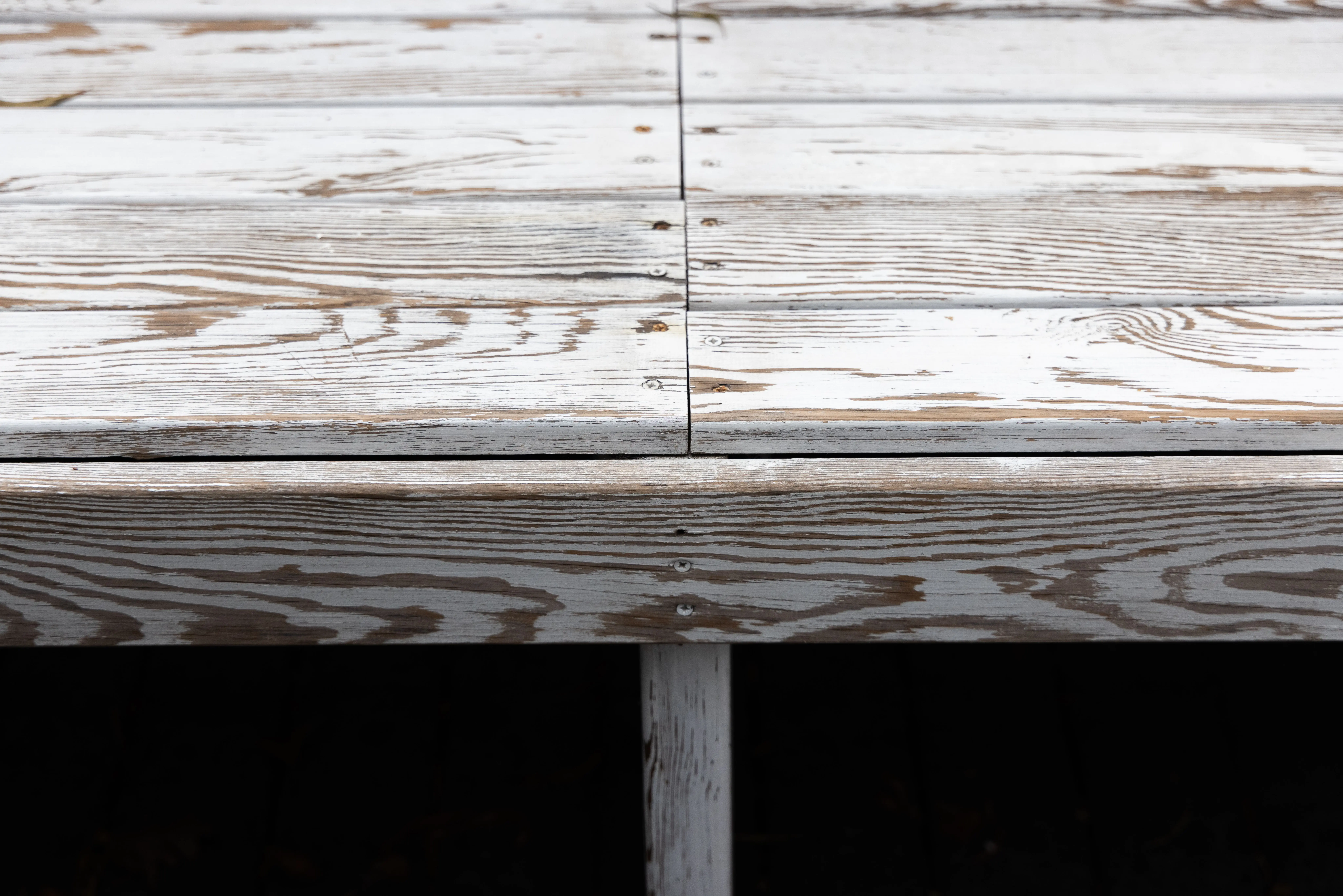 patio paint Detailed view of aged wooden planks, showing texture and screws for rustic design ideas.
