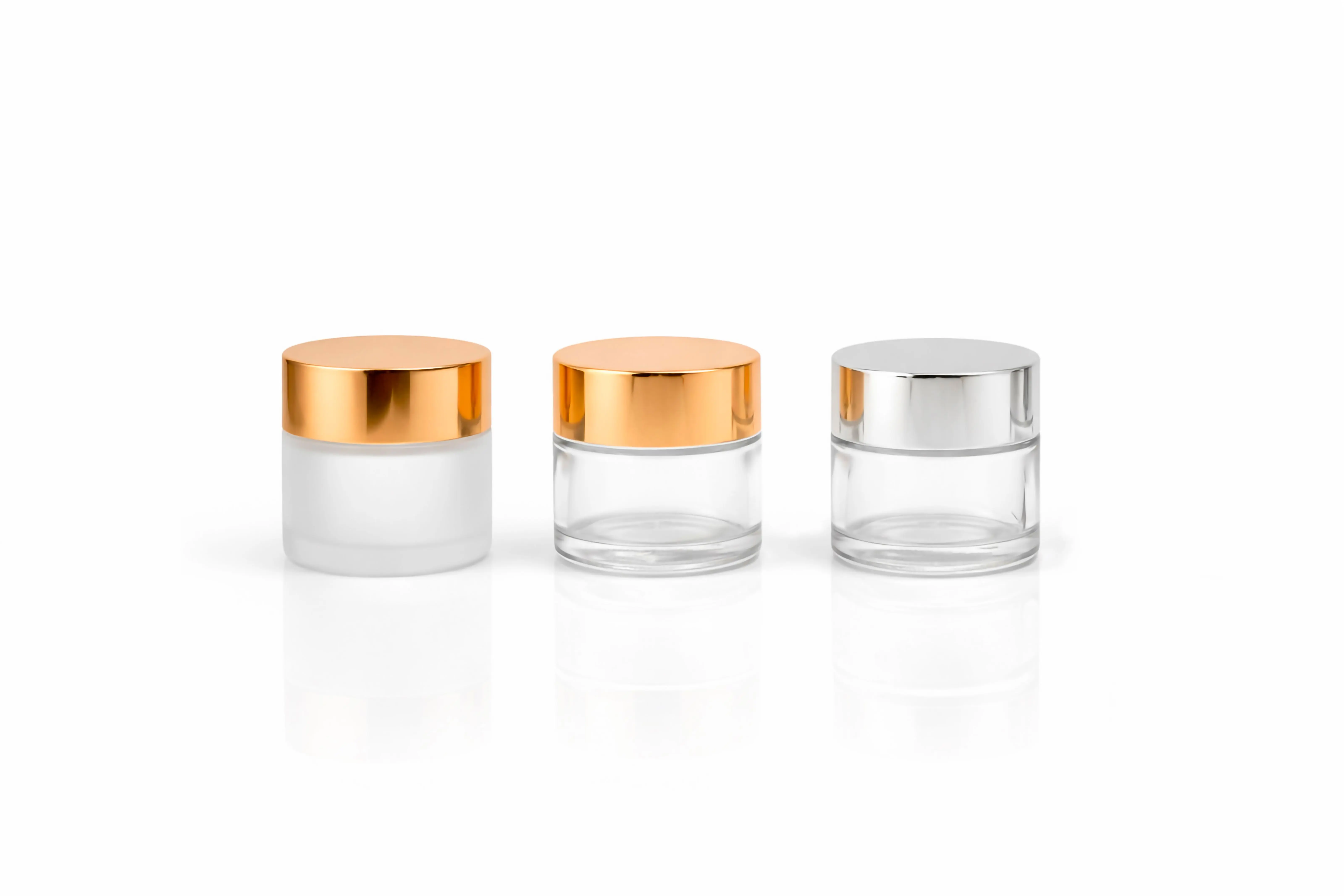 glassware storage containers Stylish glass cosmetic jars with metallic lids on a white background, perfect for beauty packaging concepts.