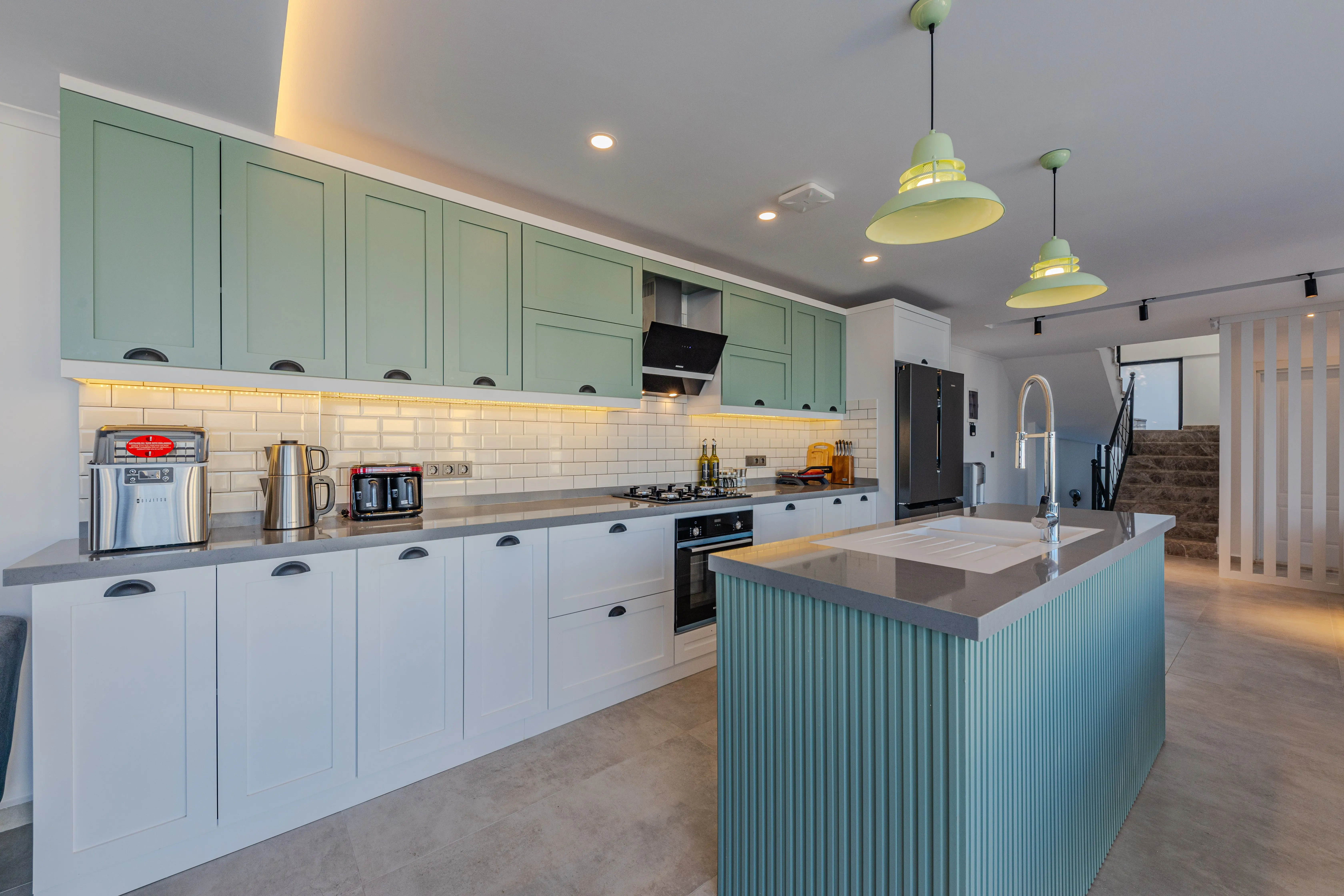 green backsplash Stylish kitchen featuring contemporary design, an island, and modern appliances.