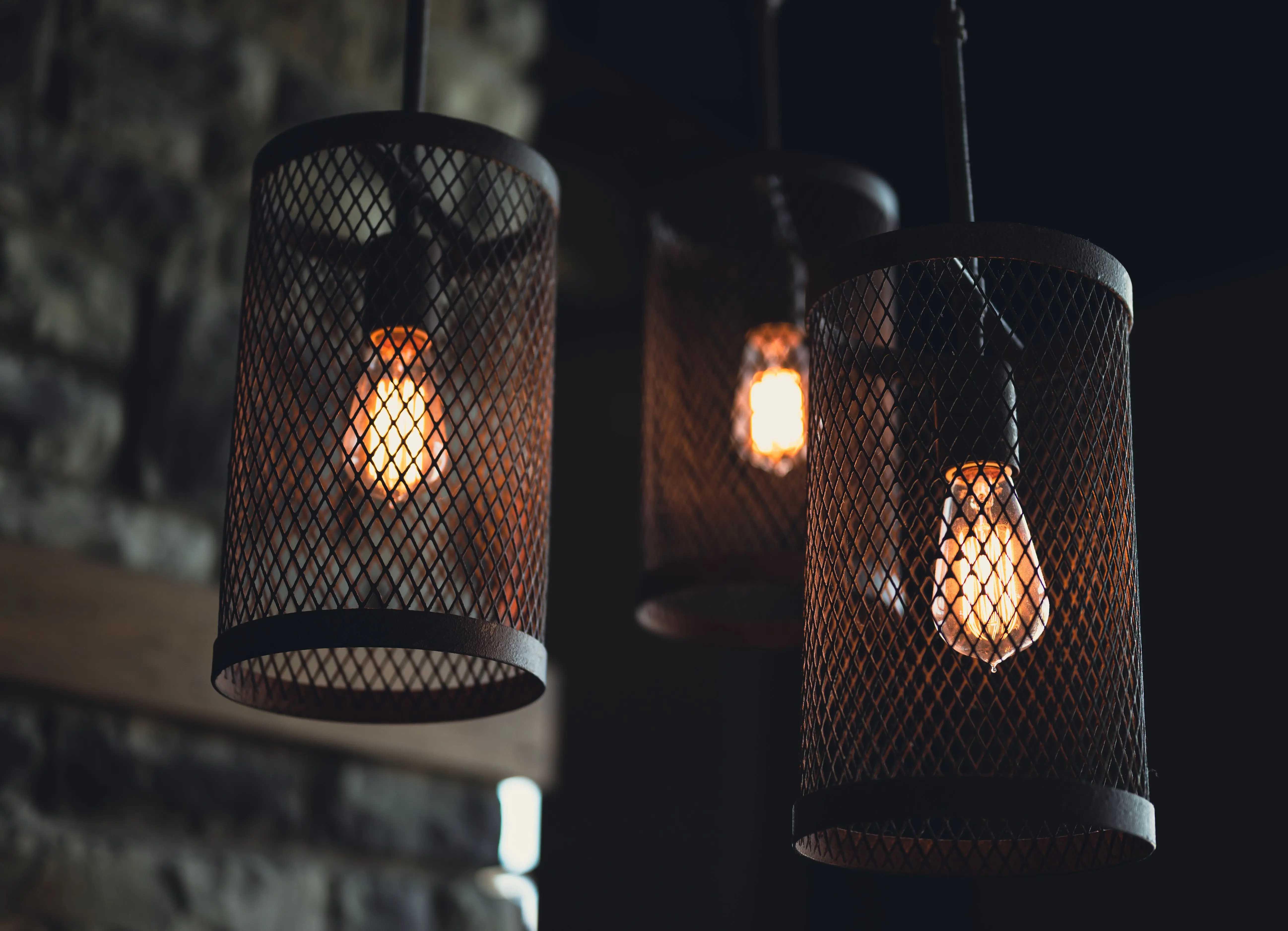 industrial furniture Close-up of rustic industrial hanging mesh light fixtures indoors.
