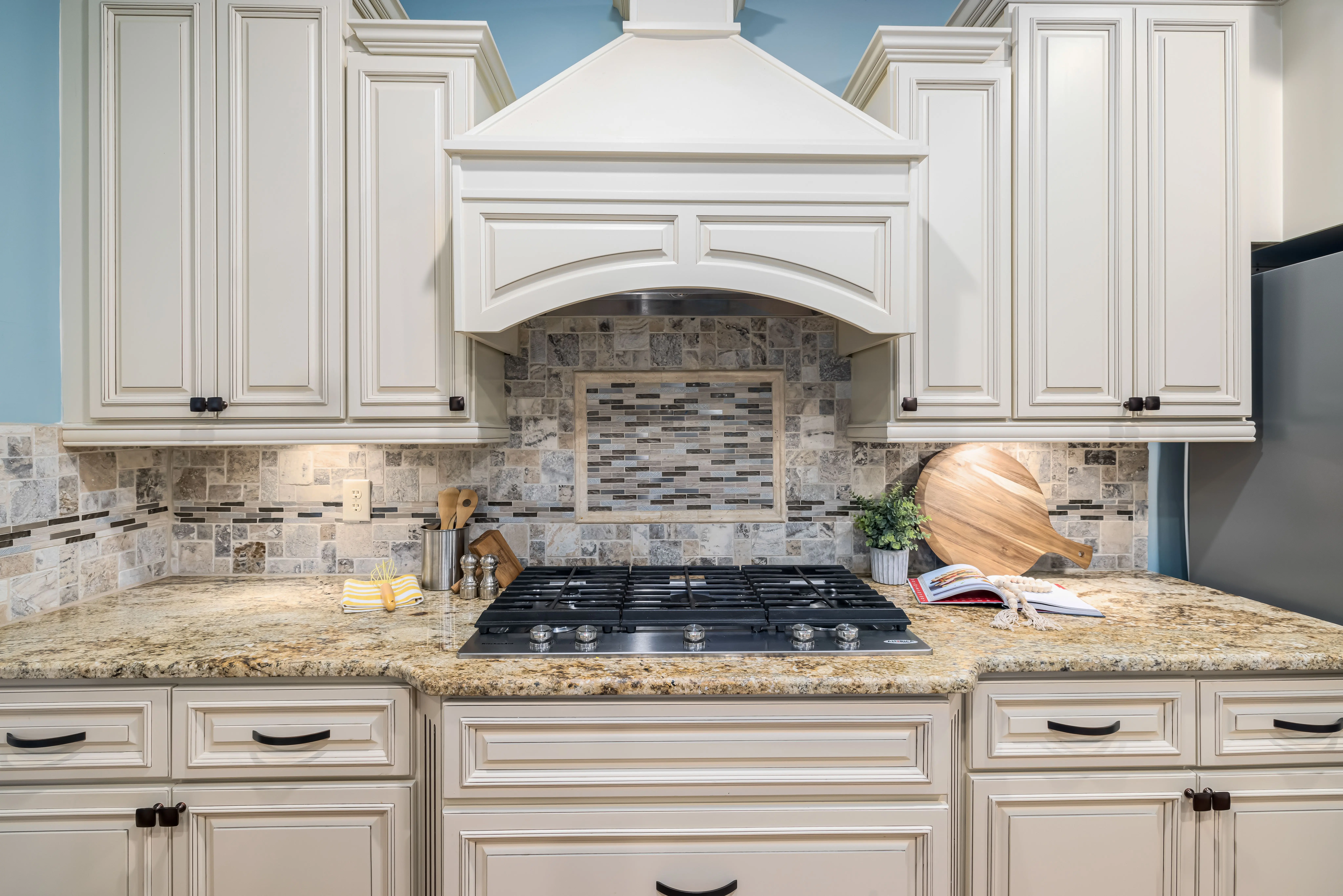 white shaker kitchen cabinets Elegant kitchen interior featuring marble countertops, wooden cabinets, and modern appliances.
