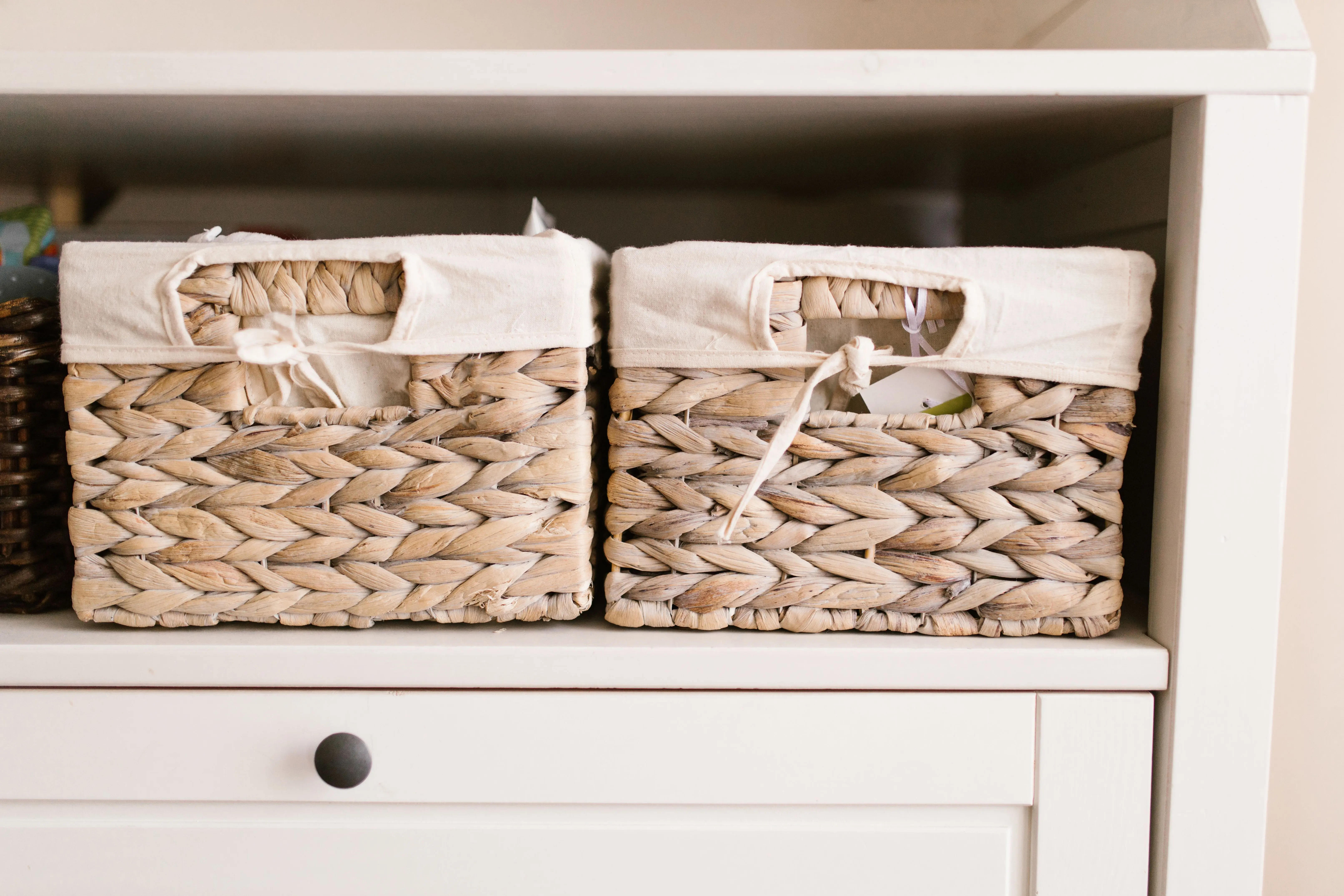 large baskets Stylish woven baskets neatly arranged on a white shelf for home organization solutions.