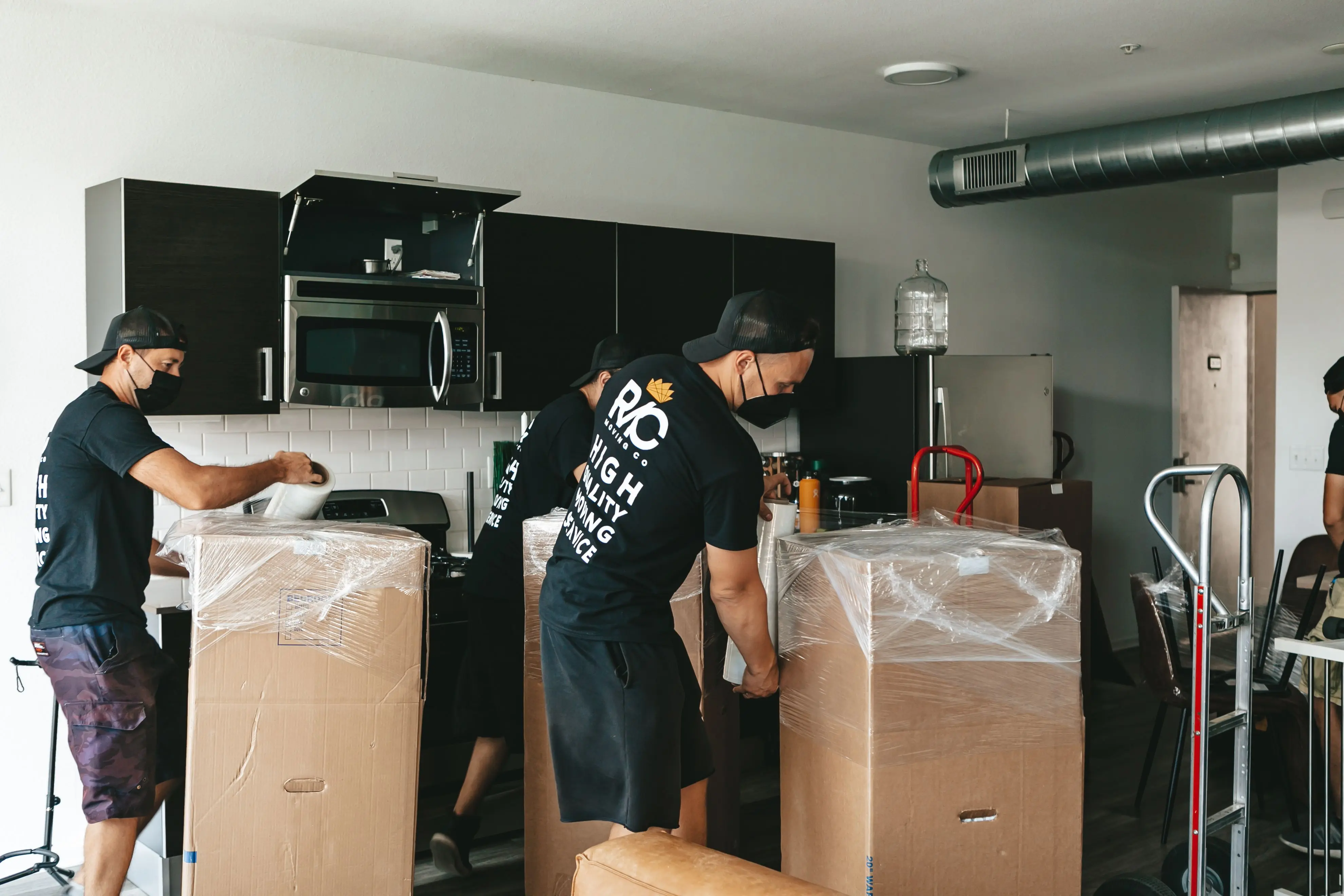 how much does a washer weigh Team of movers unpacking boxes in a modern kitchen setting. Efficient and organized moving service.