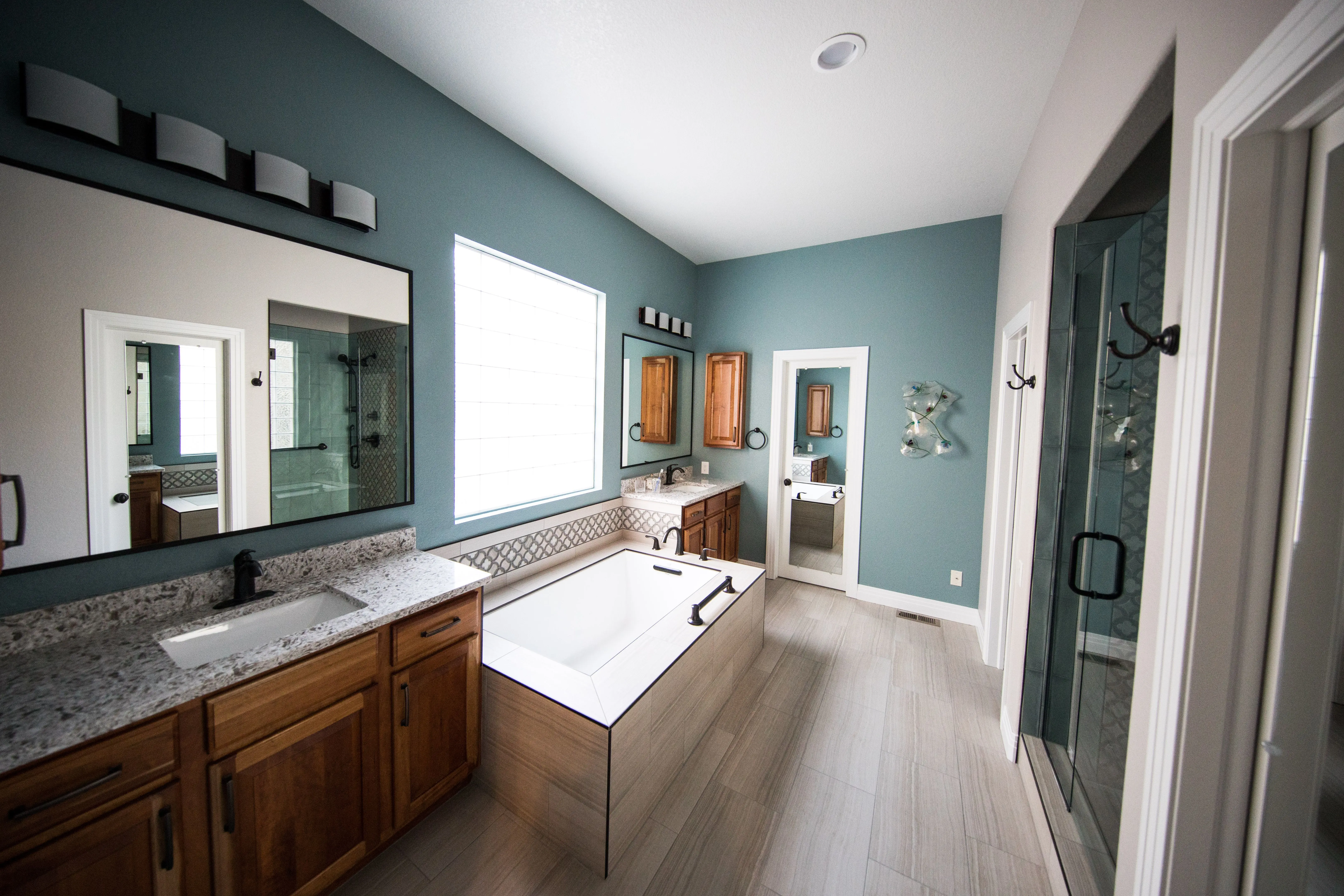 shower to bathtub conversion Spacious modern bathroom featuring a freestanding bathtub, wooden cabinets, and granite countertops.