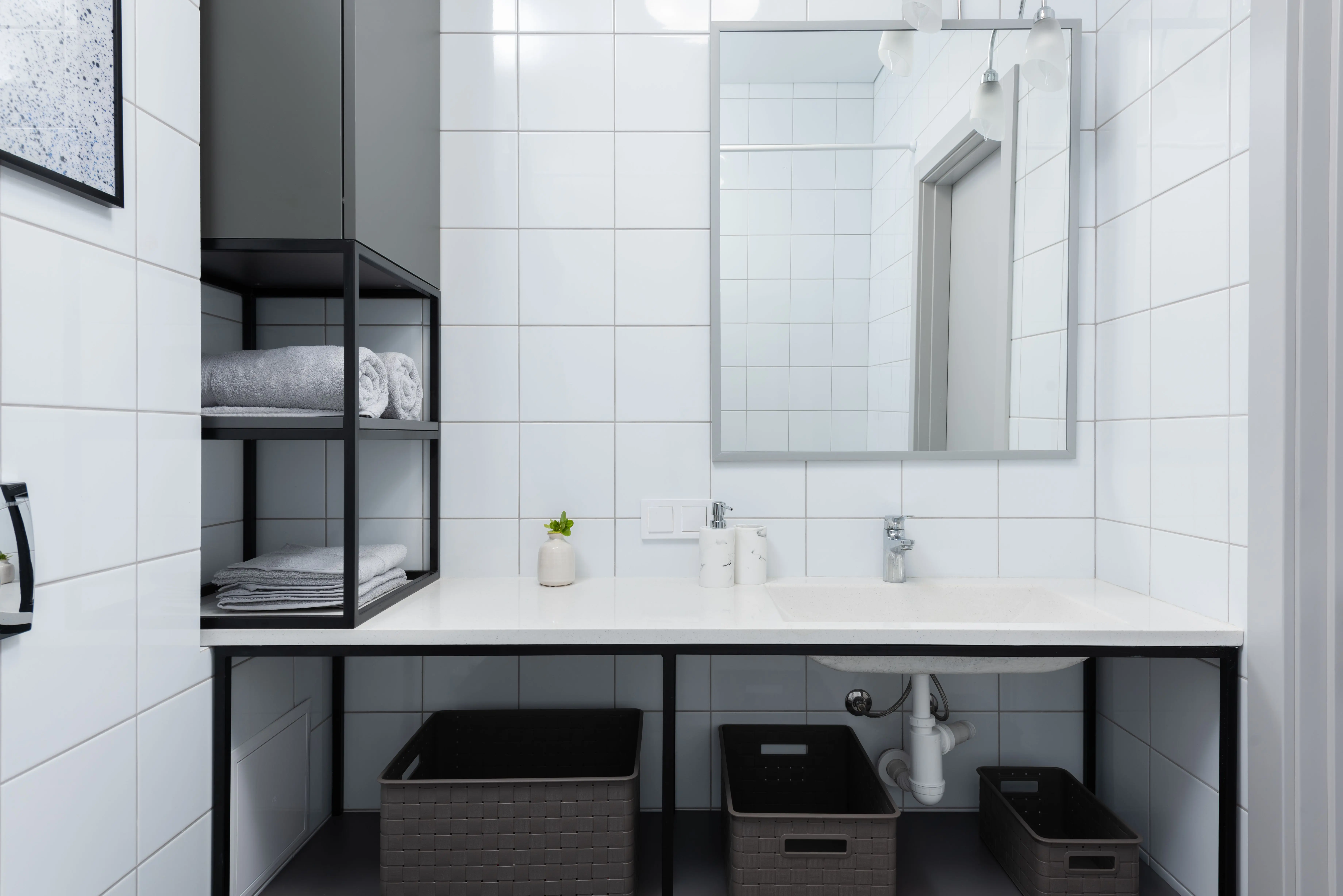 small master bathroom designs Interior of light bathroom with white counter near shelves with containers and towels near sink with faucet and mirror on tile near soap dispenser