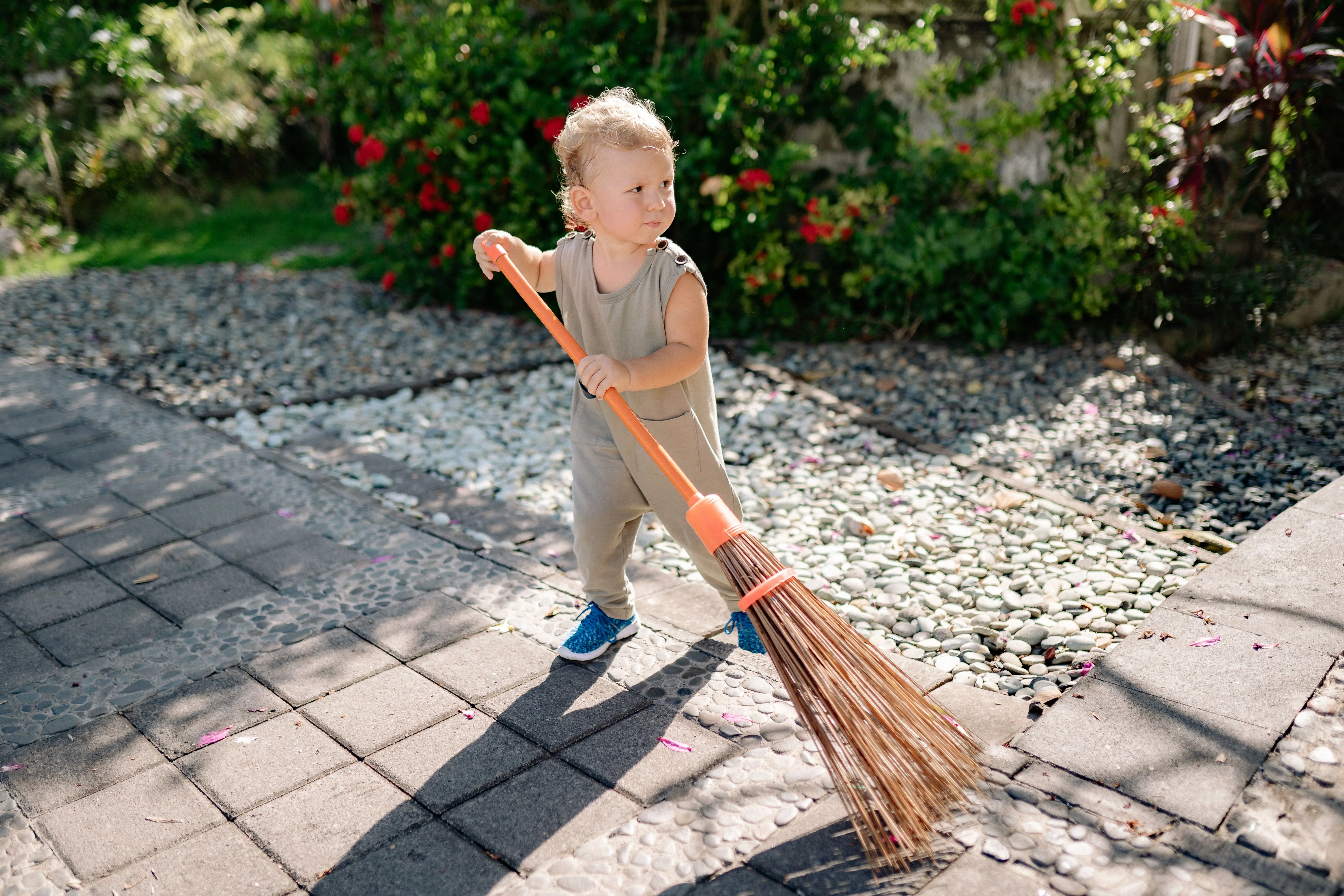 pvc fence gate A cute child sweeping a garden pathway with a broom under sunny weather.