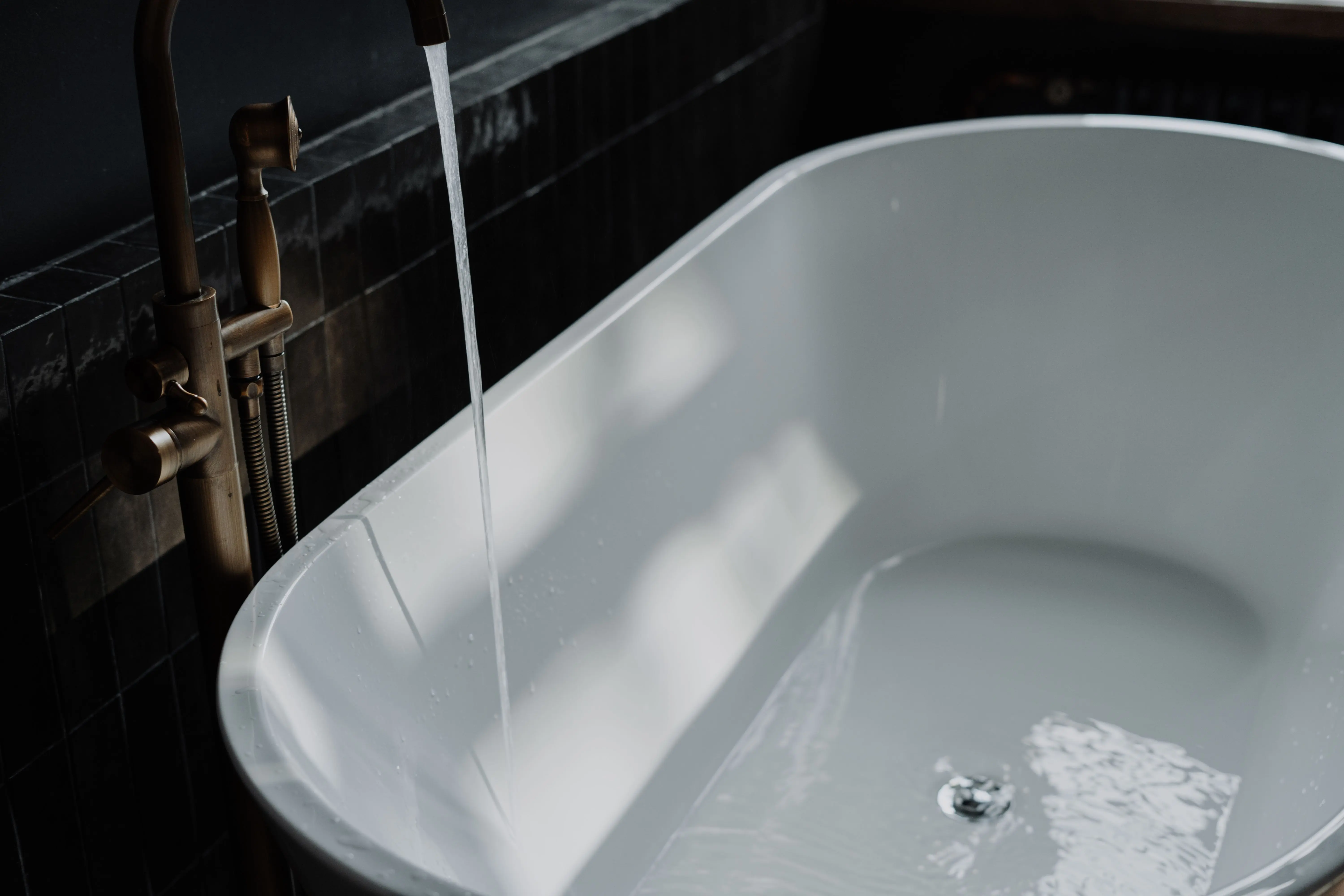 tub inside shower A serene bathroom with a modern bathtub and running water creates a relaxing atmosphere.