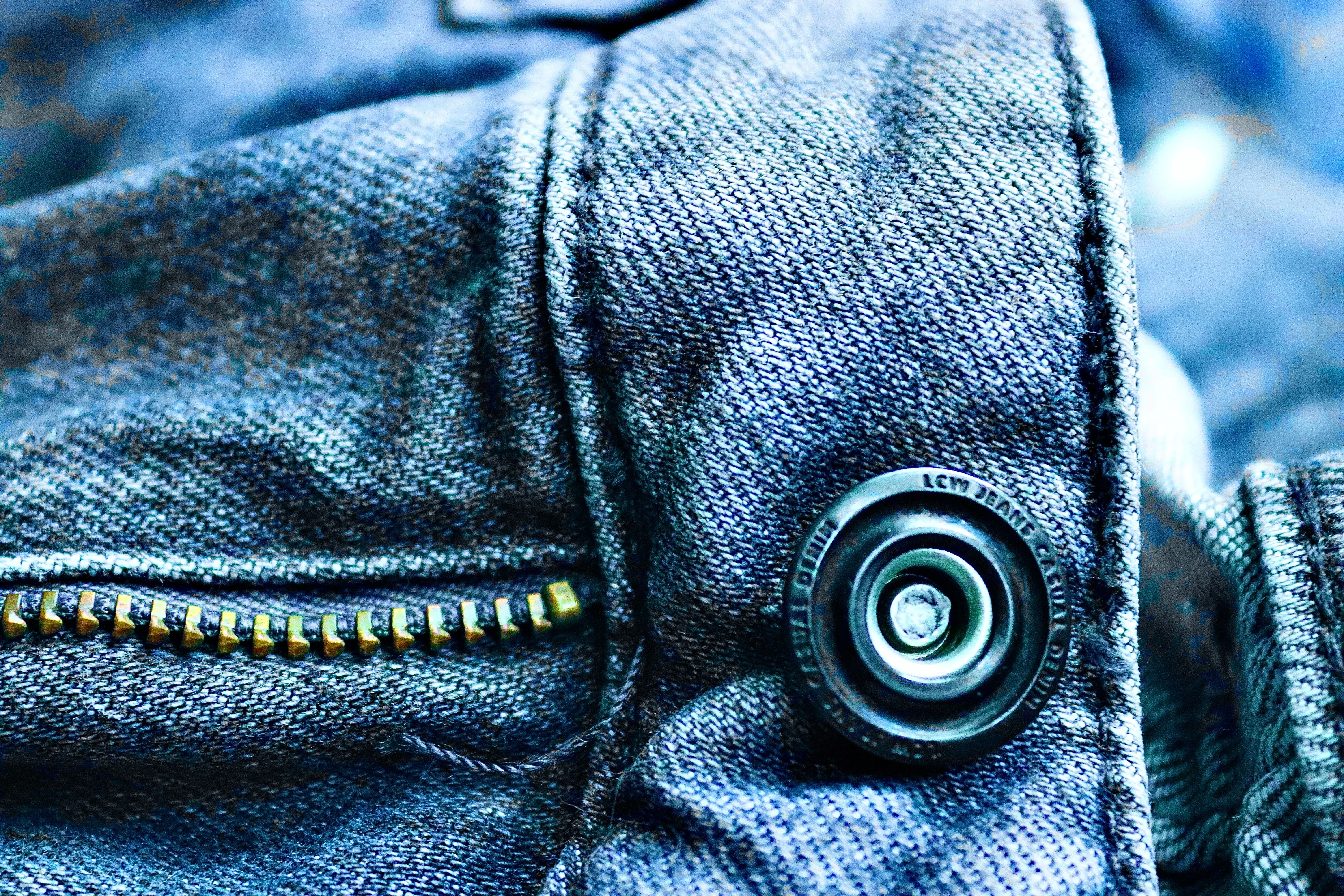 how to get blood out of denim Detailed close-up of denim fabric highlighting a button and zipper, showcasing texture and design.