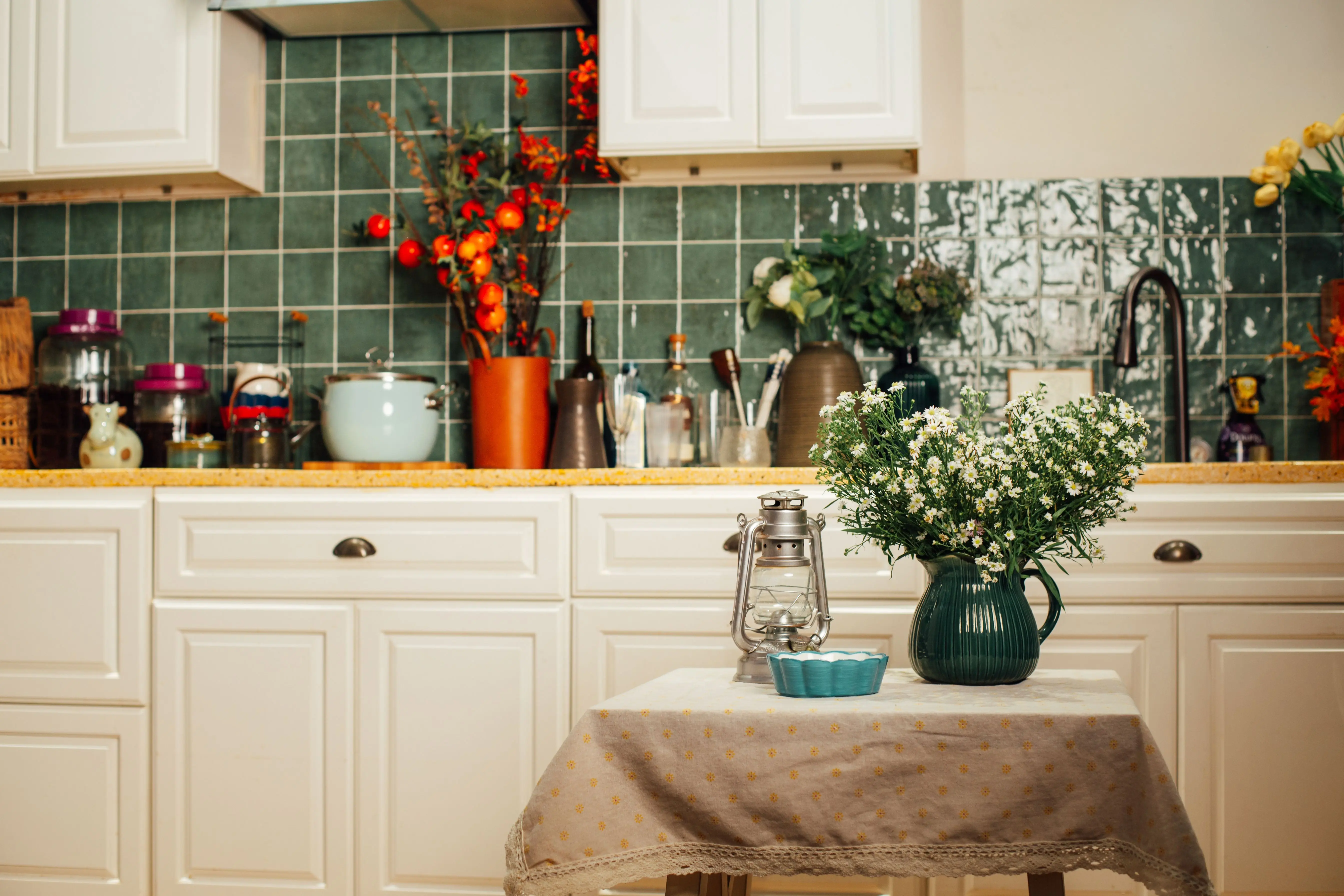 rustic cabinets Warm and inviting kitchen scene featuring potted flowers, vintage decor, and classic white cabinets.