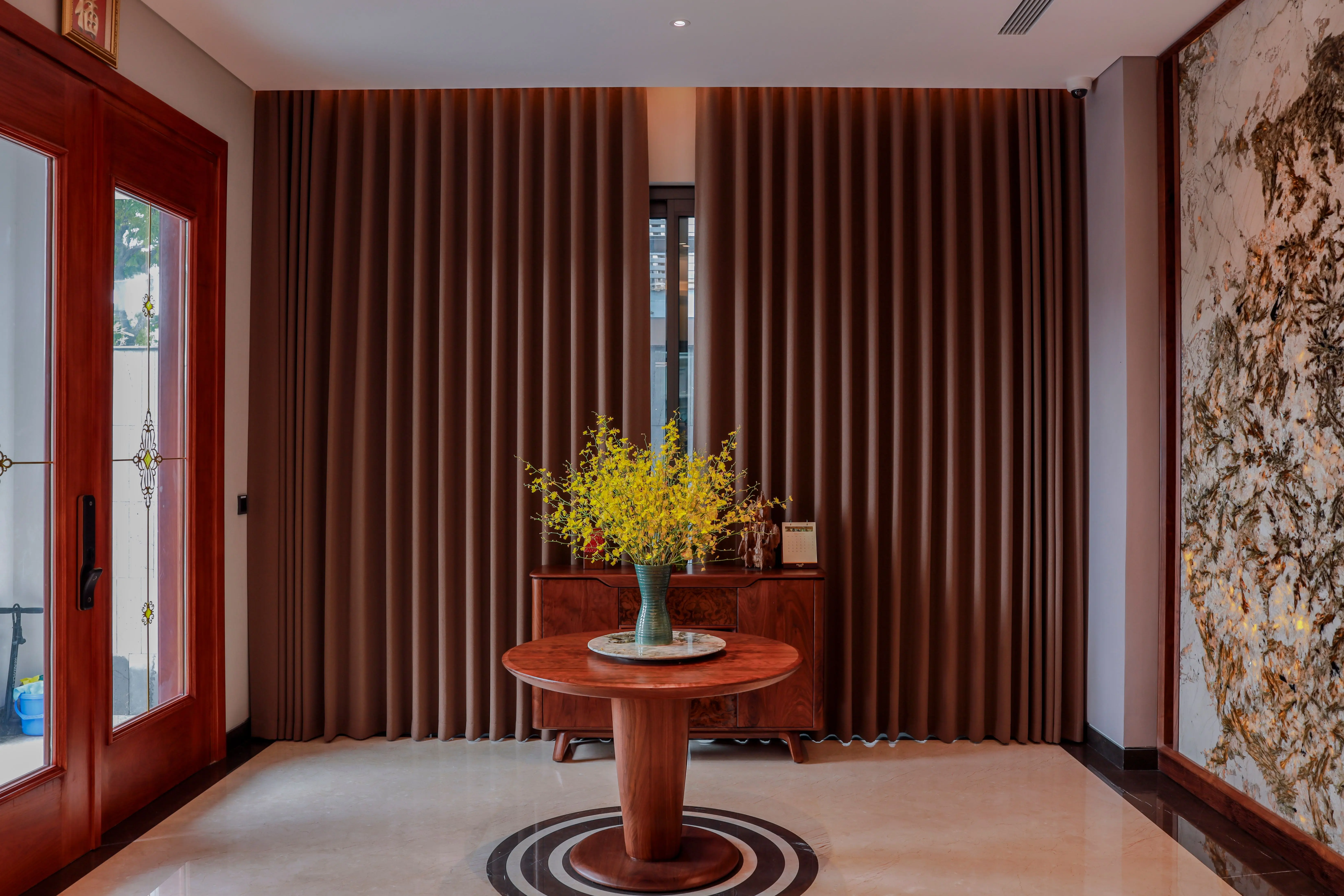 patterned drapes Sophisticated interior design featuring a wooden table with a floral centerpiece and elegant drapery.