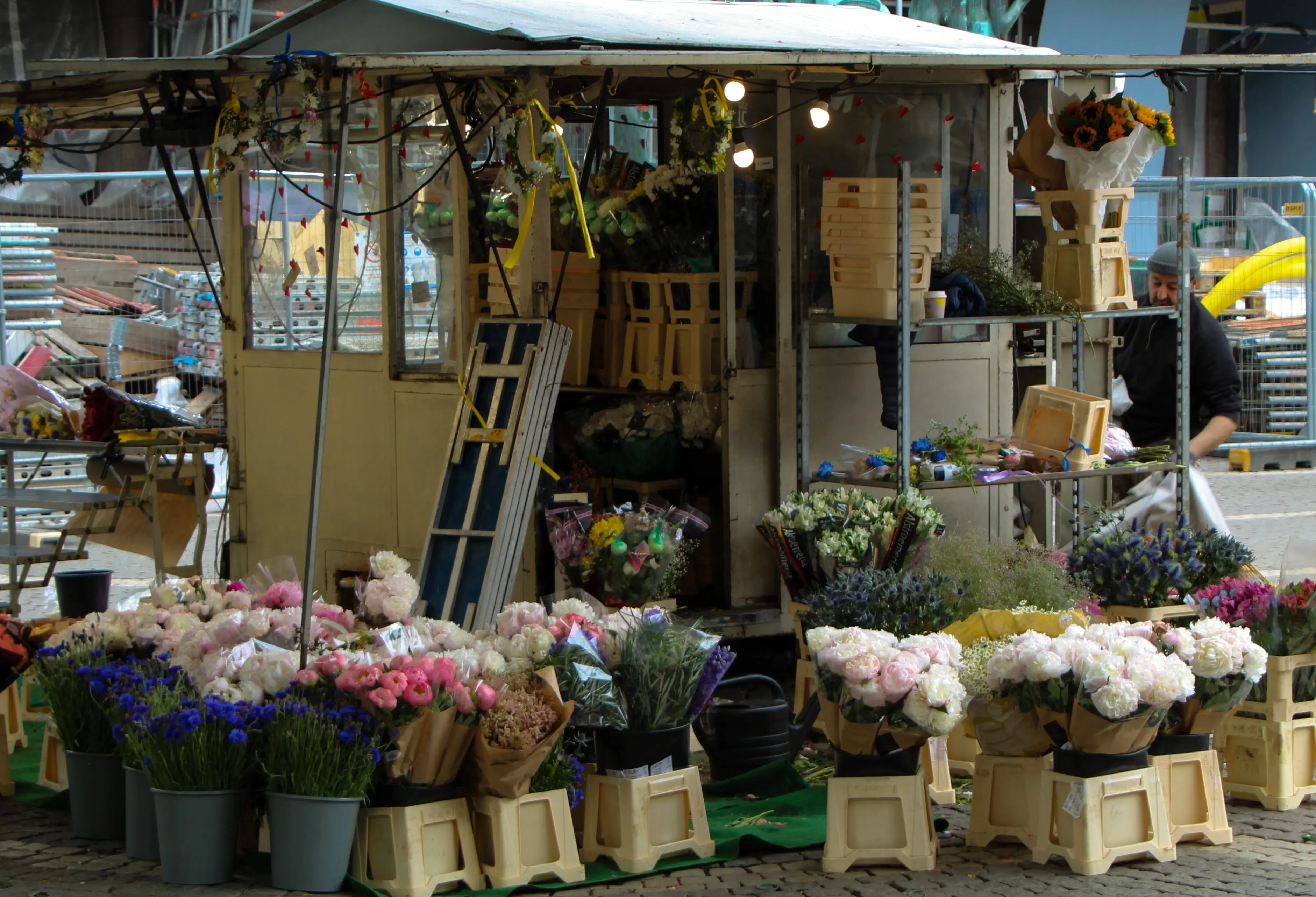 huge bouquet of flowers An inviting outdoor flower stall showcasing vibrant bouquets and assorted flowers in a busy market street.