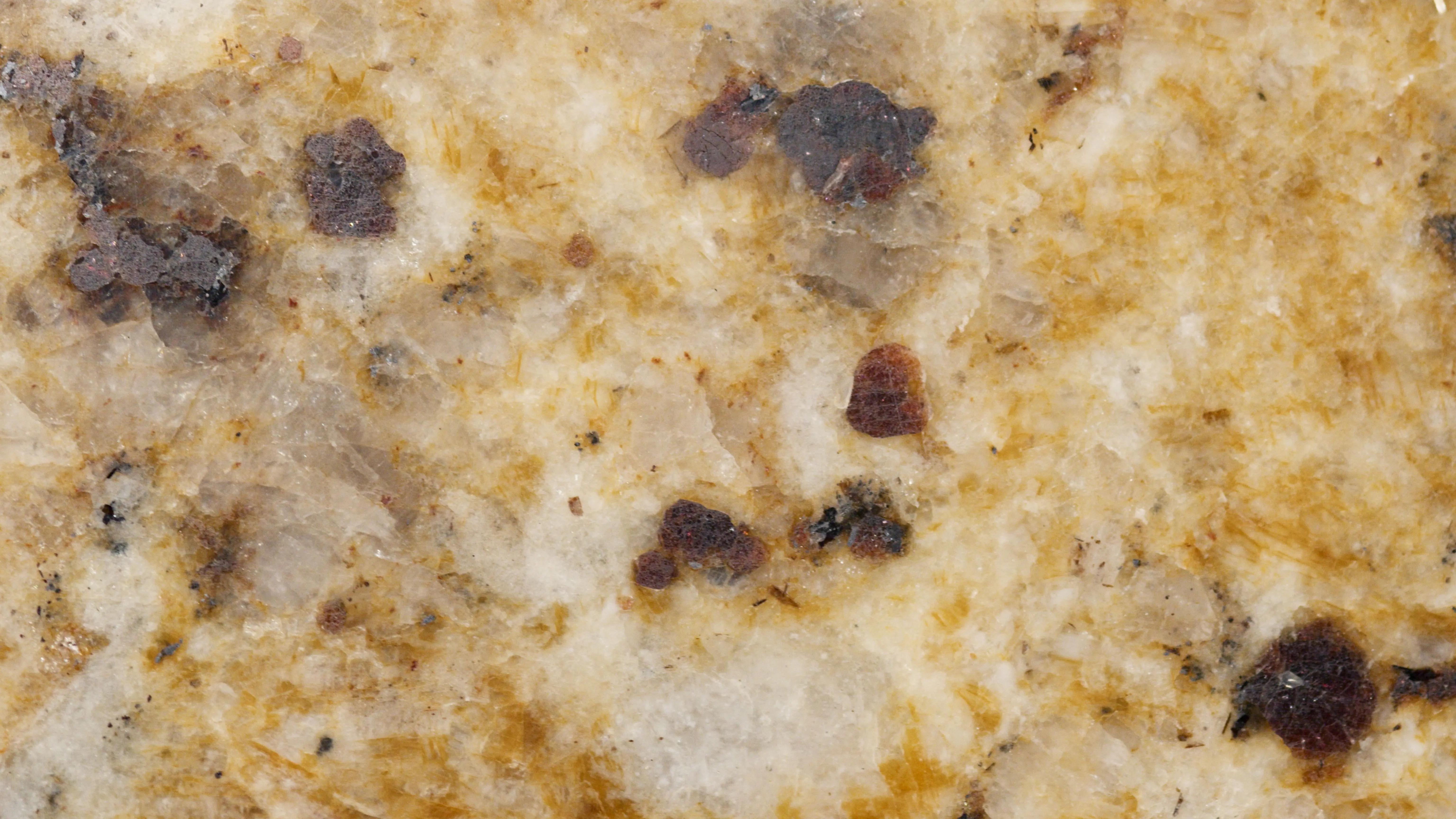 green granite Detailed close-up of a textured granite surface with earthy tones and patterns.