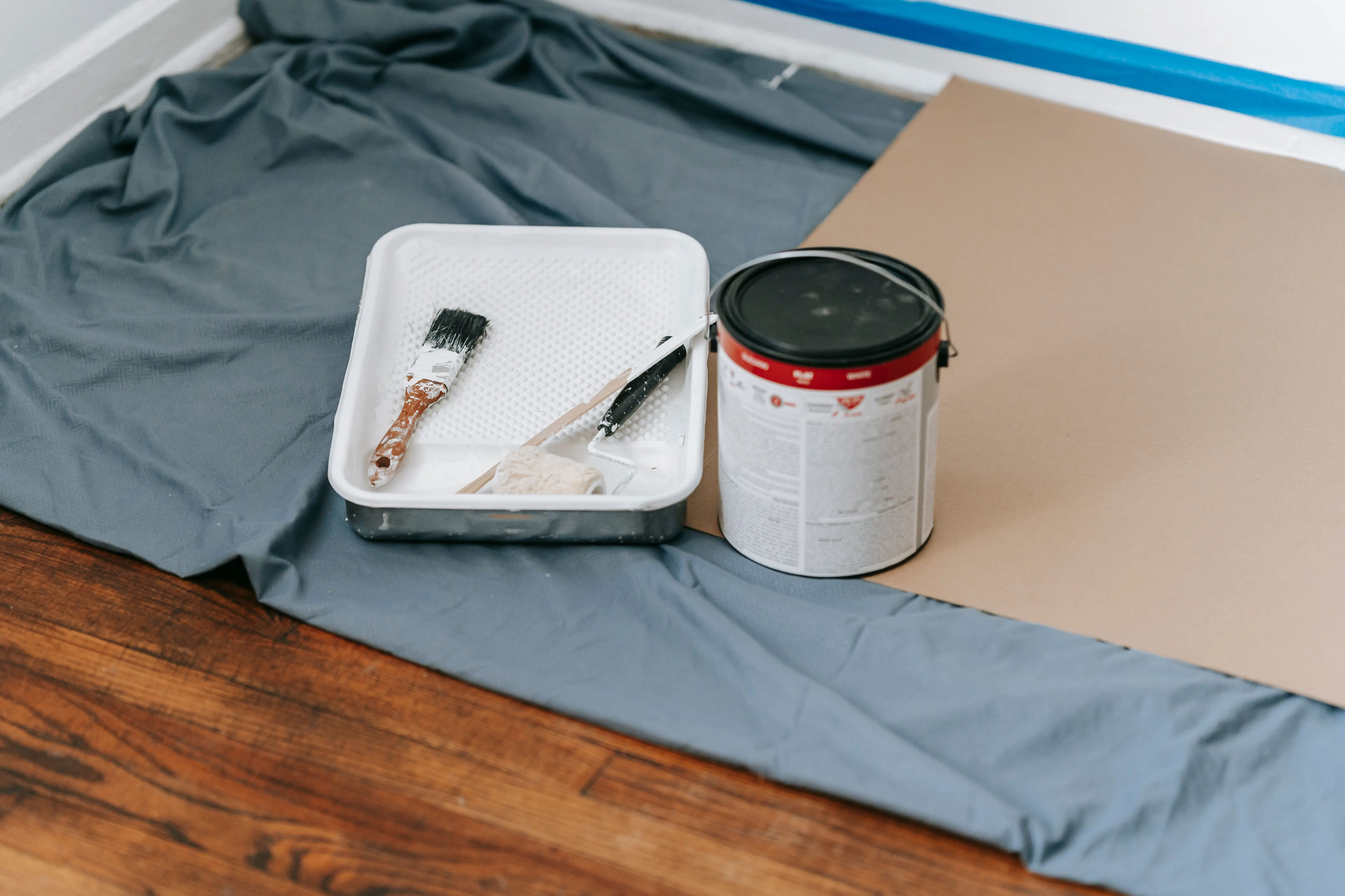 painting price per square foot A collection of painting tools and materials prepared for a home renovation project indoors.