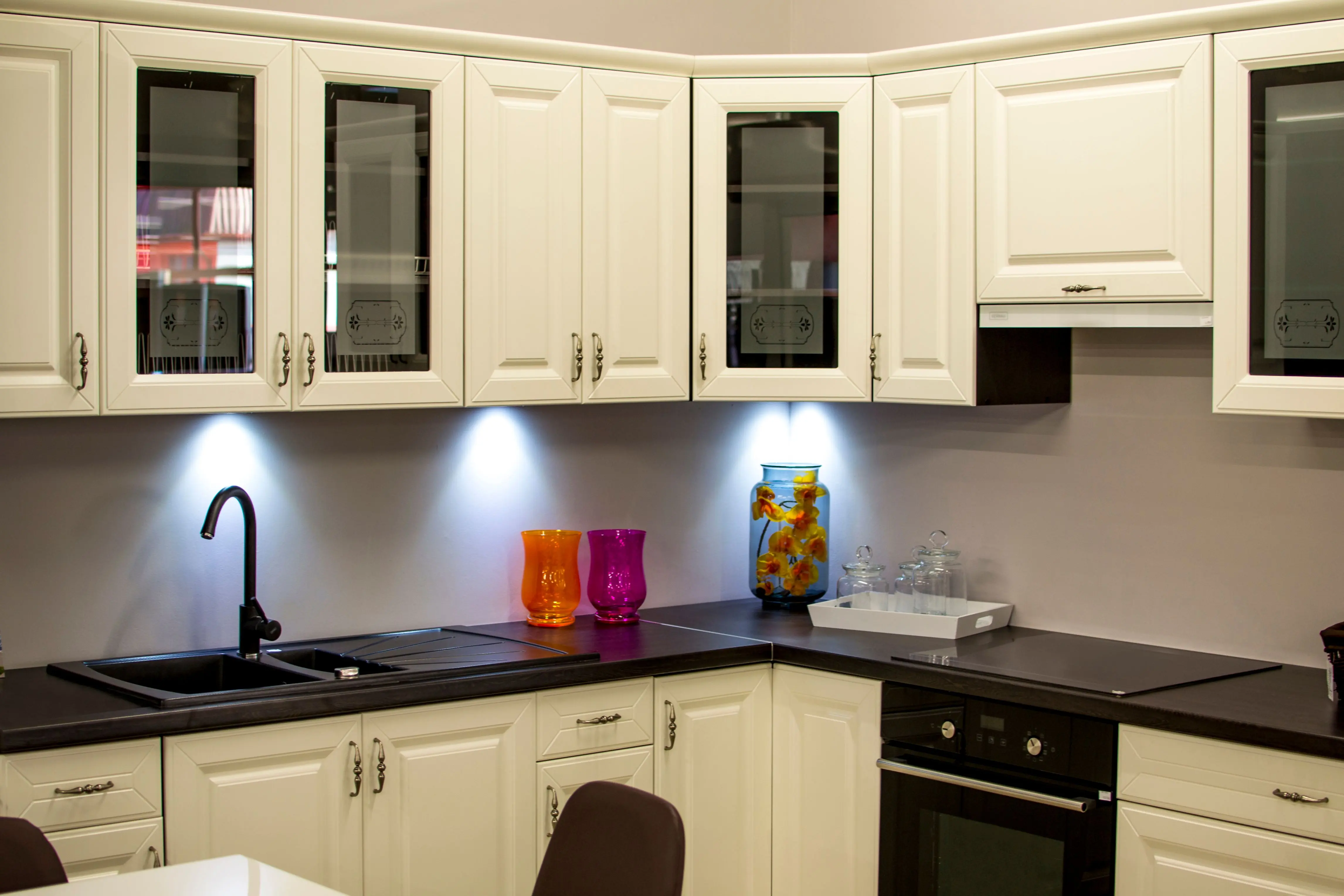 modern kitchen cabinet pulls A stylish modern kitchen with white cabinets and colorful decor pieces.