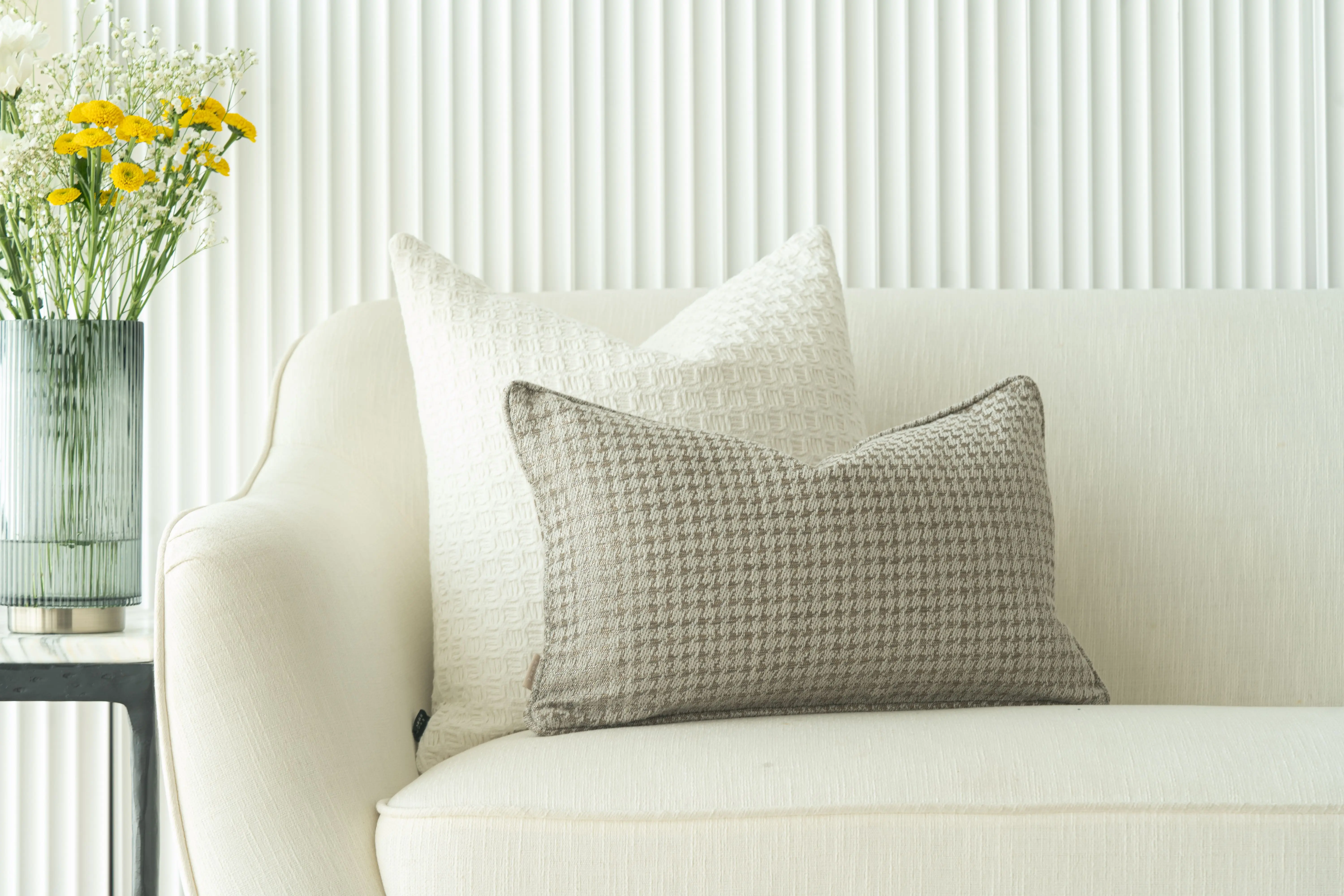 lumbar pillow covers Elegant living room featuring a white sofa, decorative pillows, and a vase of yellow flowers.