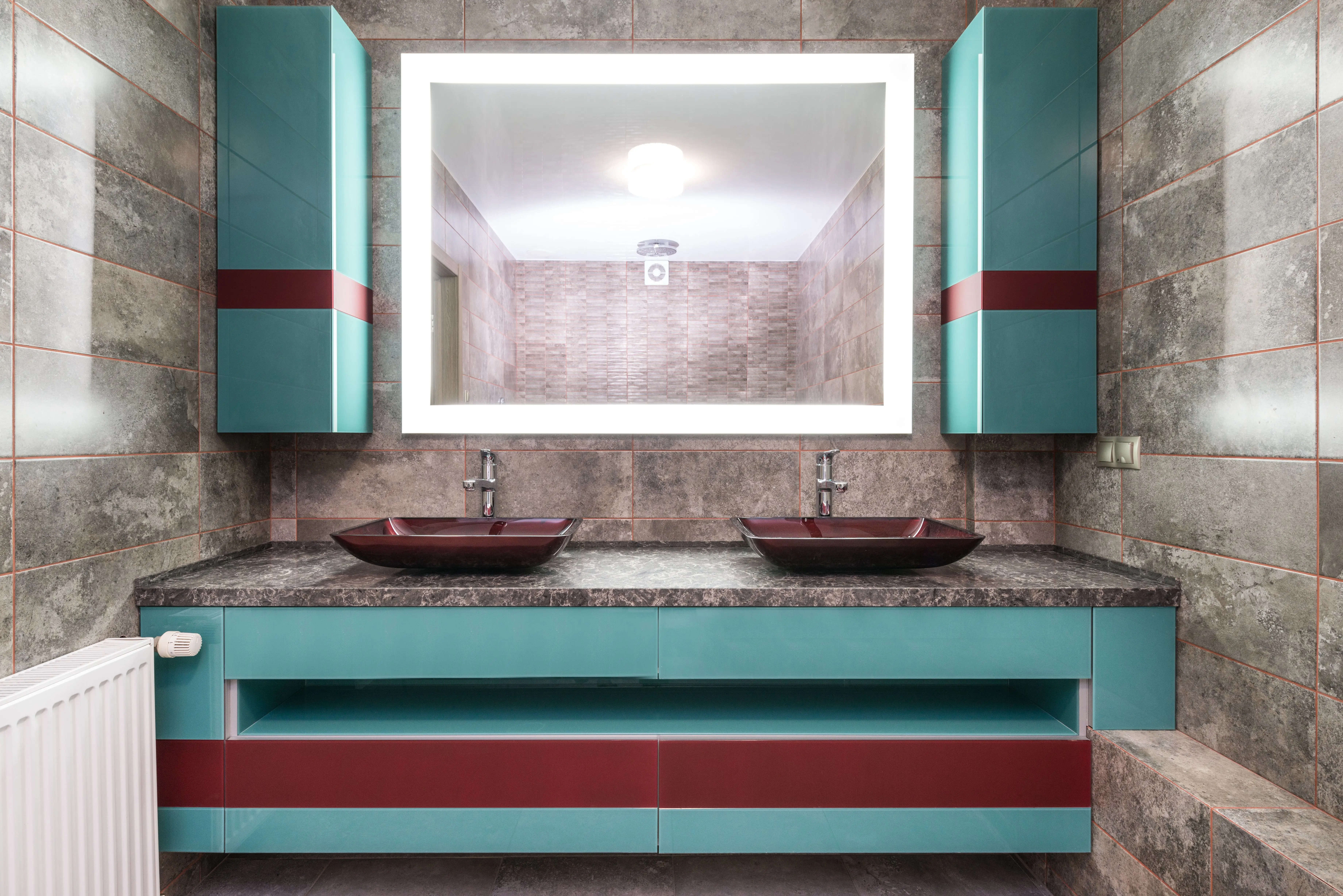sink bath Double red sinks on marble counter under turquoise cabinets and glowing mirror in modern bathroom with tiled walls